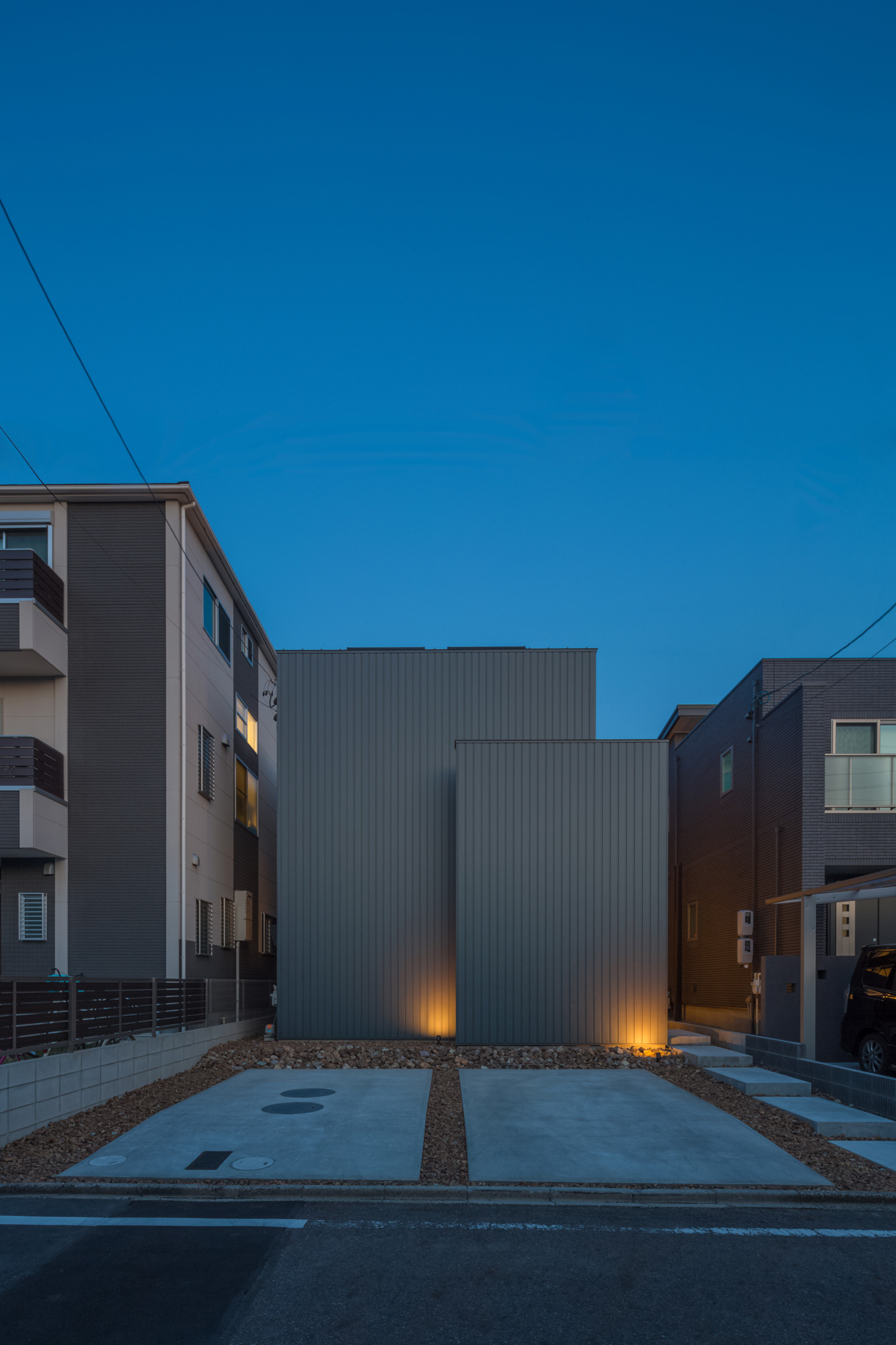 広い駐車スペースがある窓のないキューブ状の家・デザイン住宅