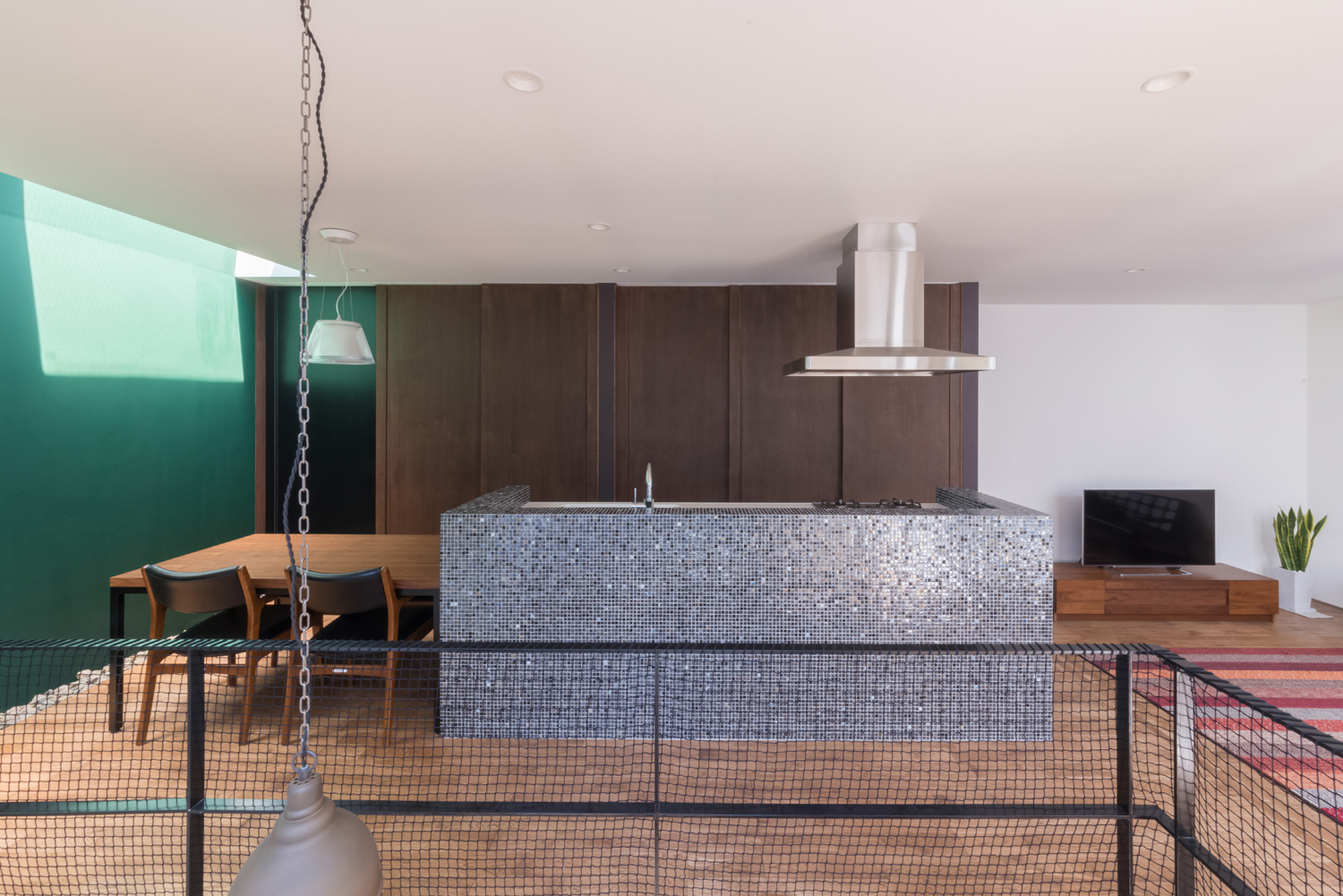 青いタイルの腰壁付きキッチンとダイニングテーブルが横並びになっているおしゃれなLDK・デザイン住宅