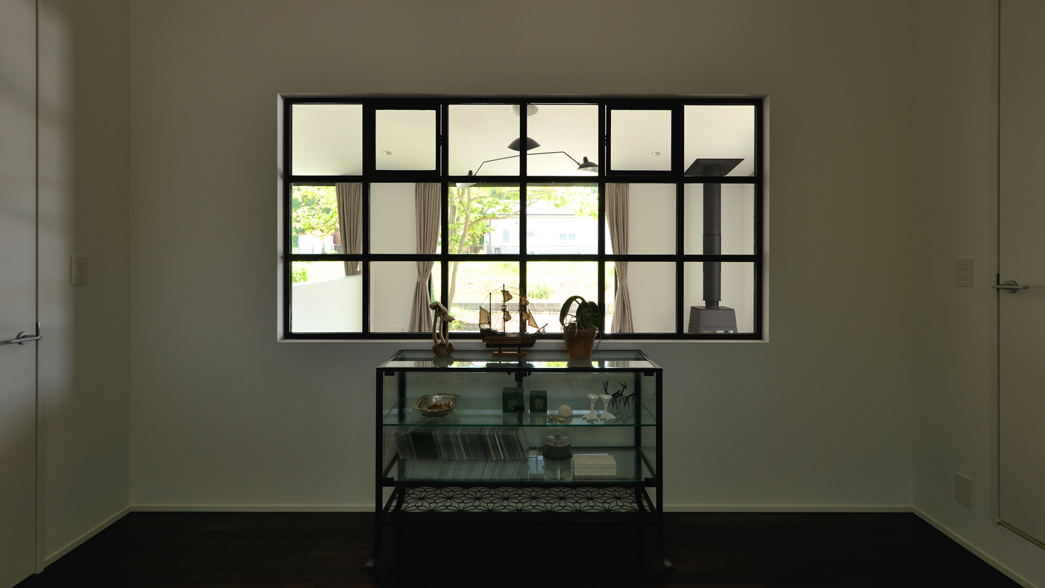 格子付きの室内窓からLDKの様子が見える書斎・デザイン住宅