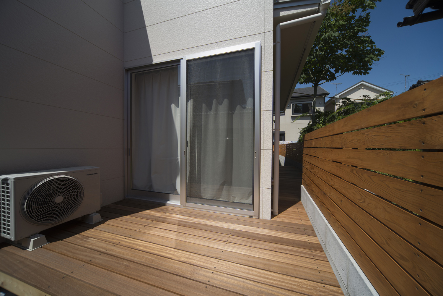 木の目隠し壁付きのシンプルなテラス・デザイン住宅