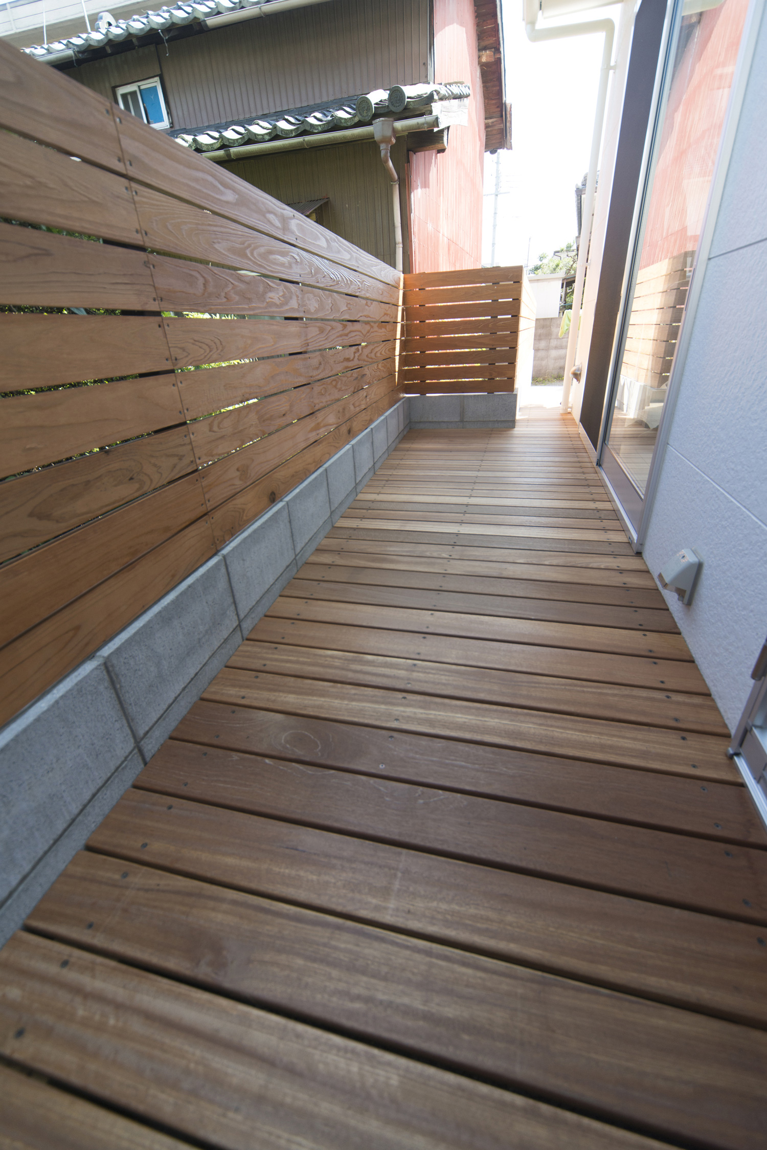 目隠し壁が取り付けられたウッドデッキのテラス・デザイン住宅