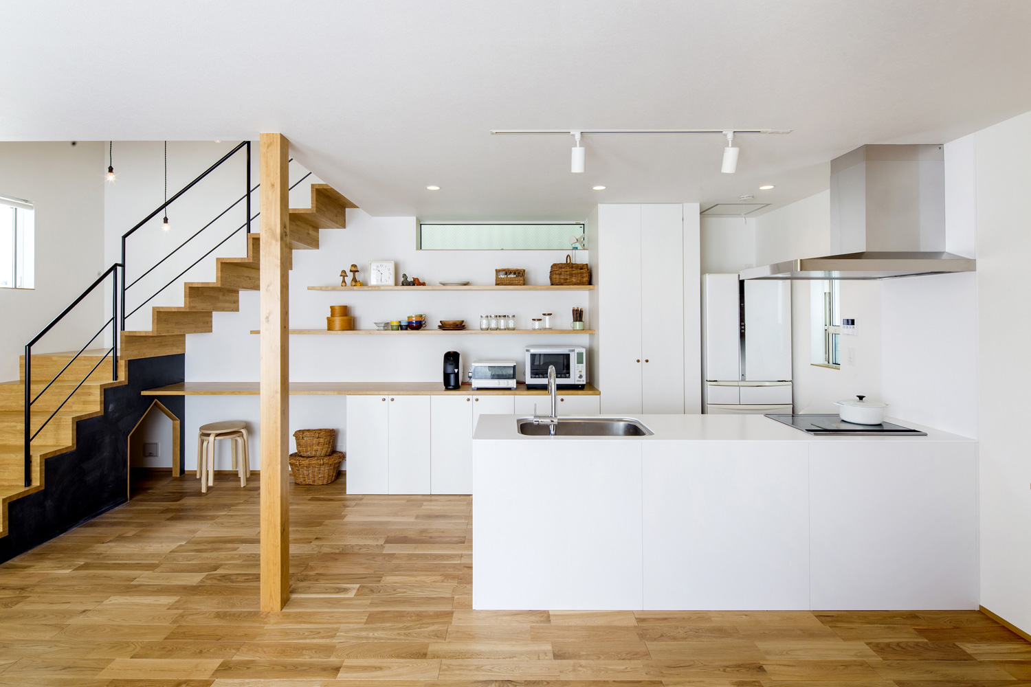 背面に見せる収納がある白いシンプルなペニンシュラキッチン・デザイン住宅