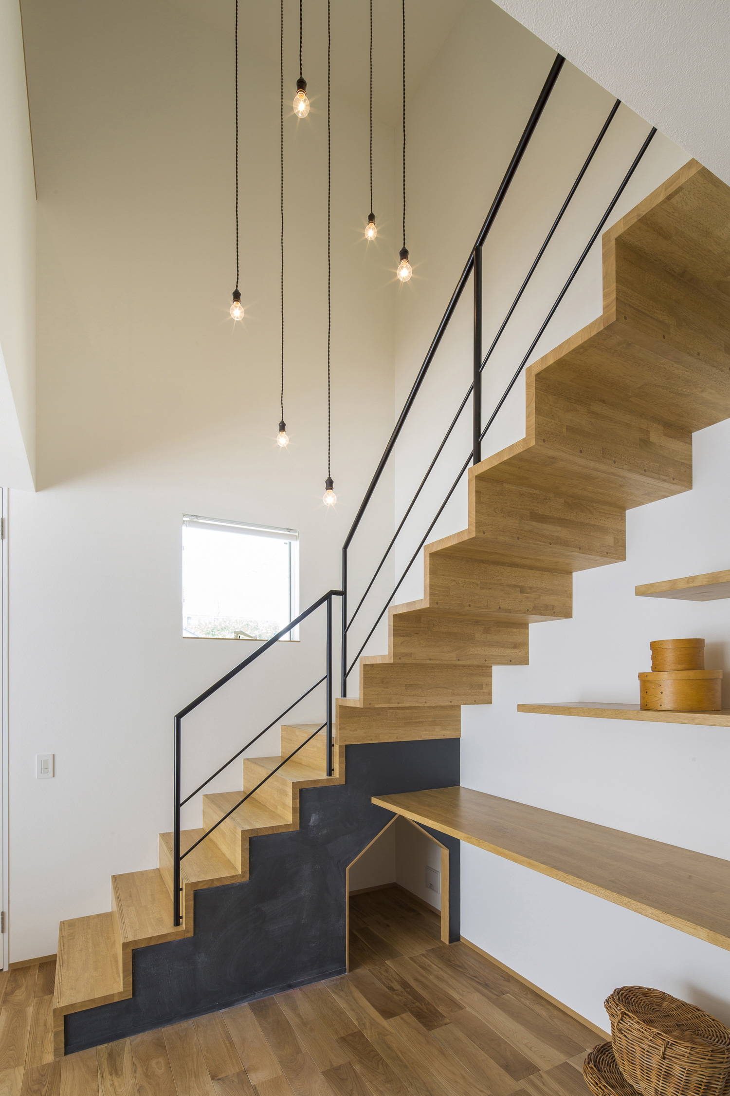 シンプルなペンダントライトに照らされる木製のスケルトン階段・デザイン住宅