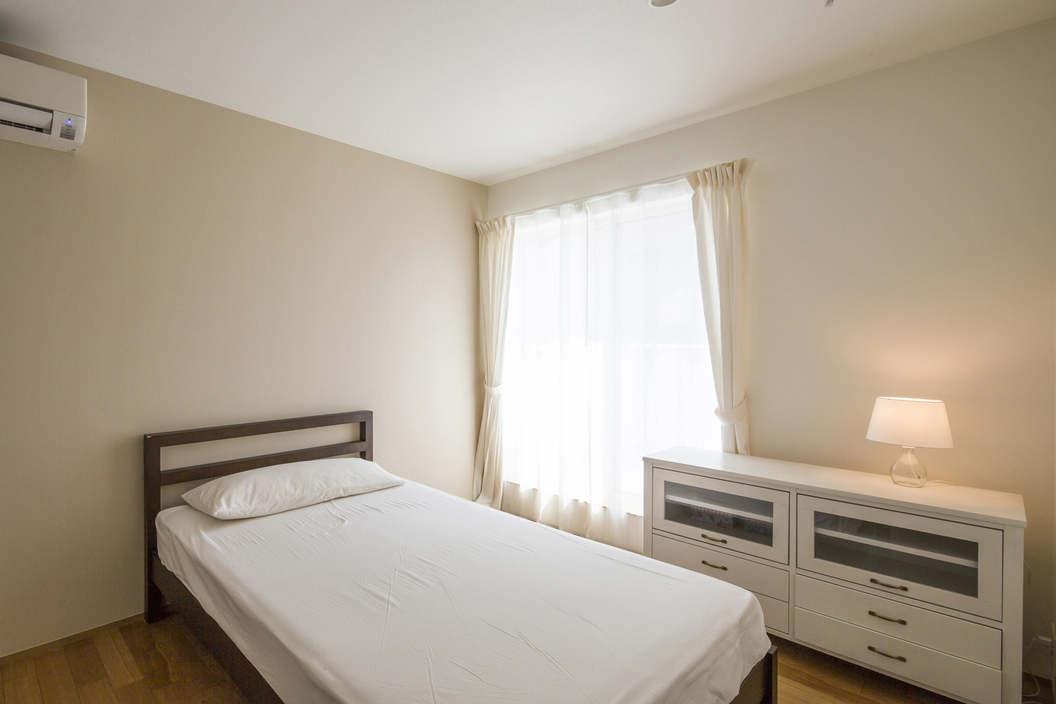 シングルベッドと収納があるシンプルな寝室・デザイン住宅