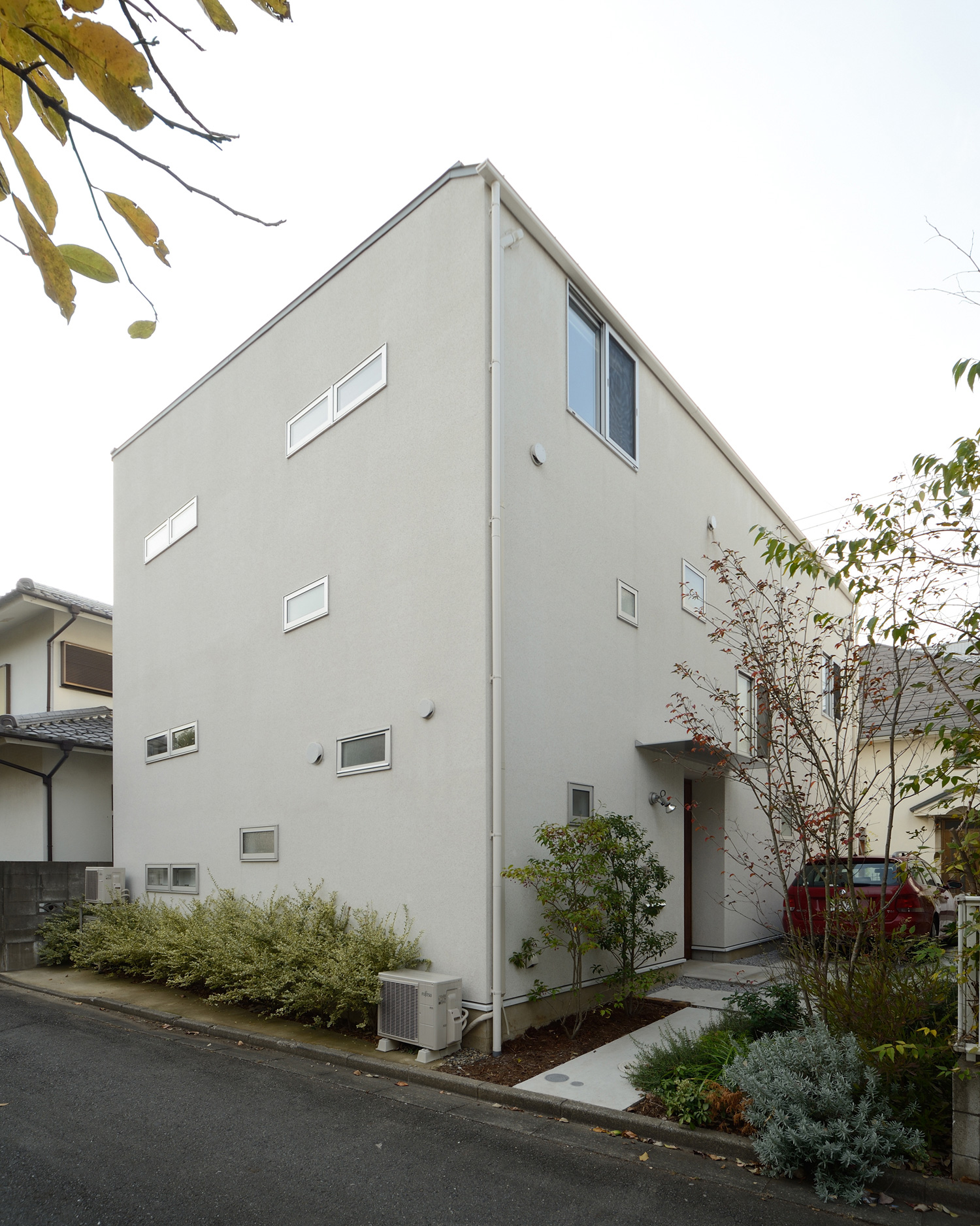 植栽に囲まれた白いキューブ状の外観の家・デザイン住宅