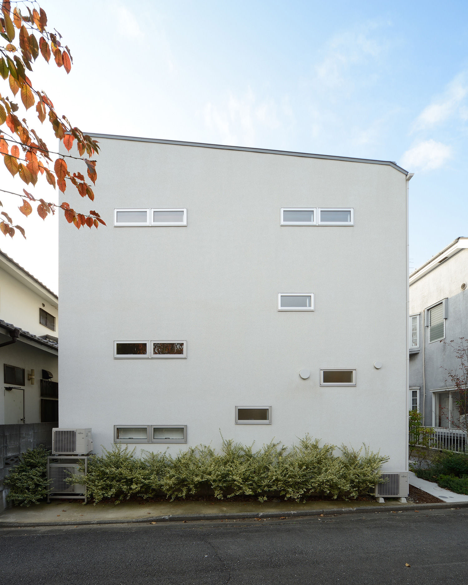 小さな窓が沢山取り付けられた白い外壁の家・デザイン住宅