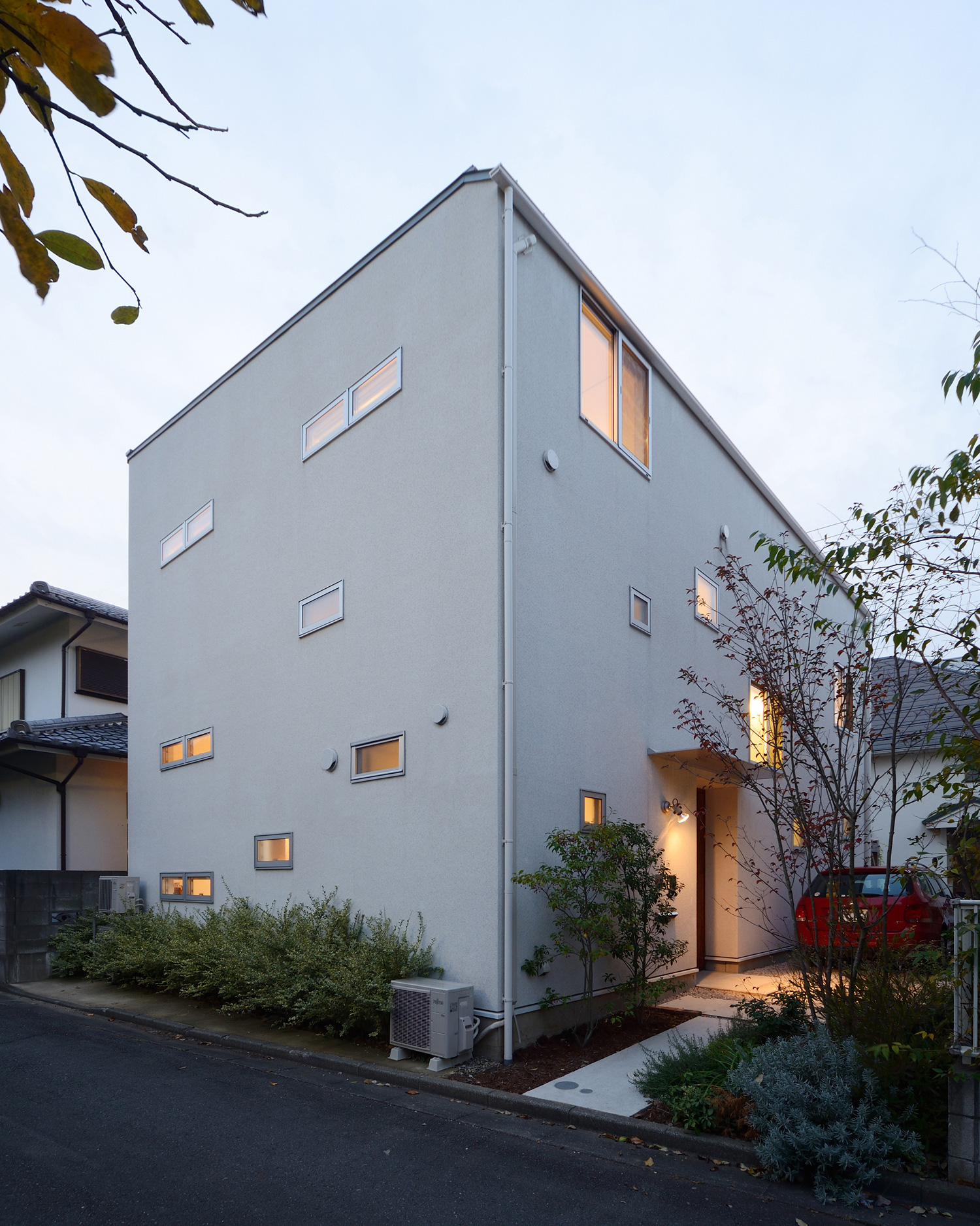 小さな窓が取り付けられたシンプルでプライバシー性の高い家・デザイン住宅