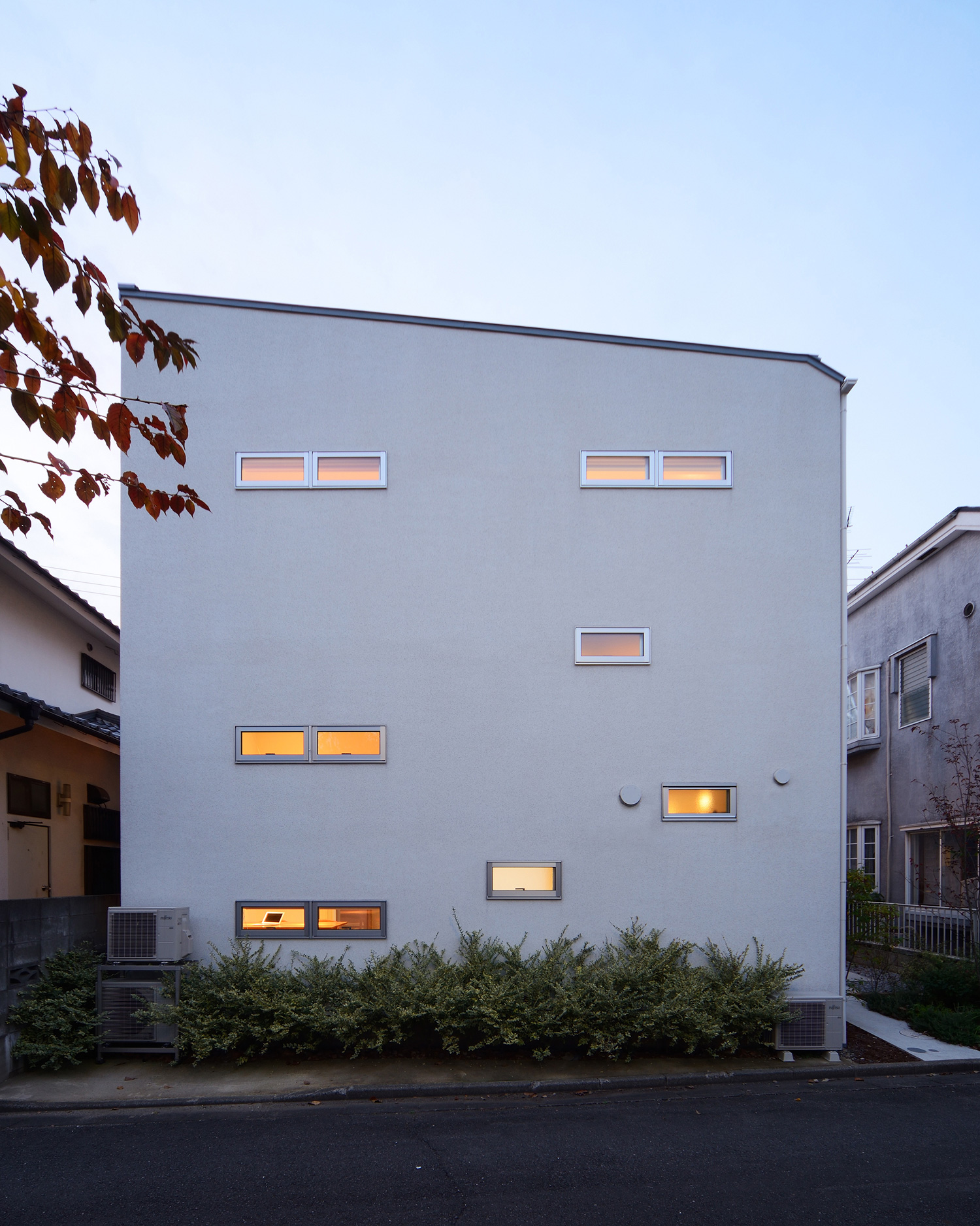 横長のスリット窓を取り付けた白い外壁・デザイン住宅