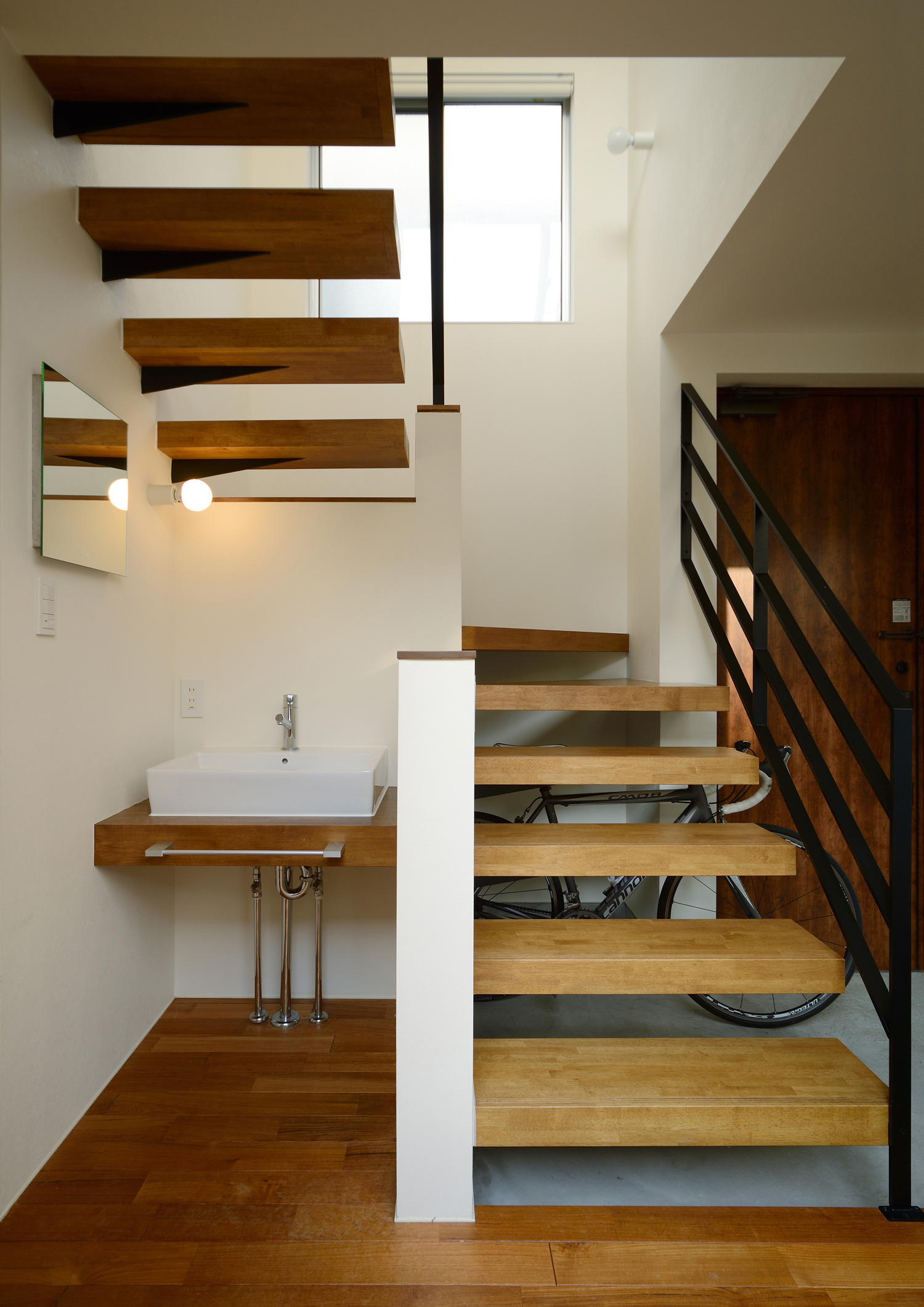 スケルトン階段のそばにあるコンパクトな手洗いカウンター・デザイン住宅