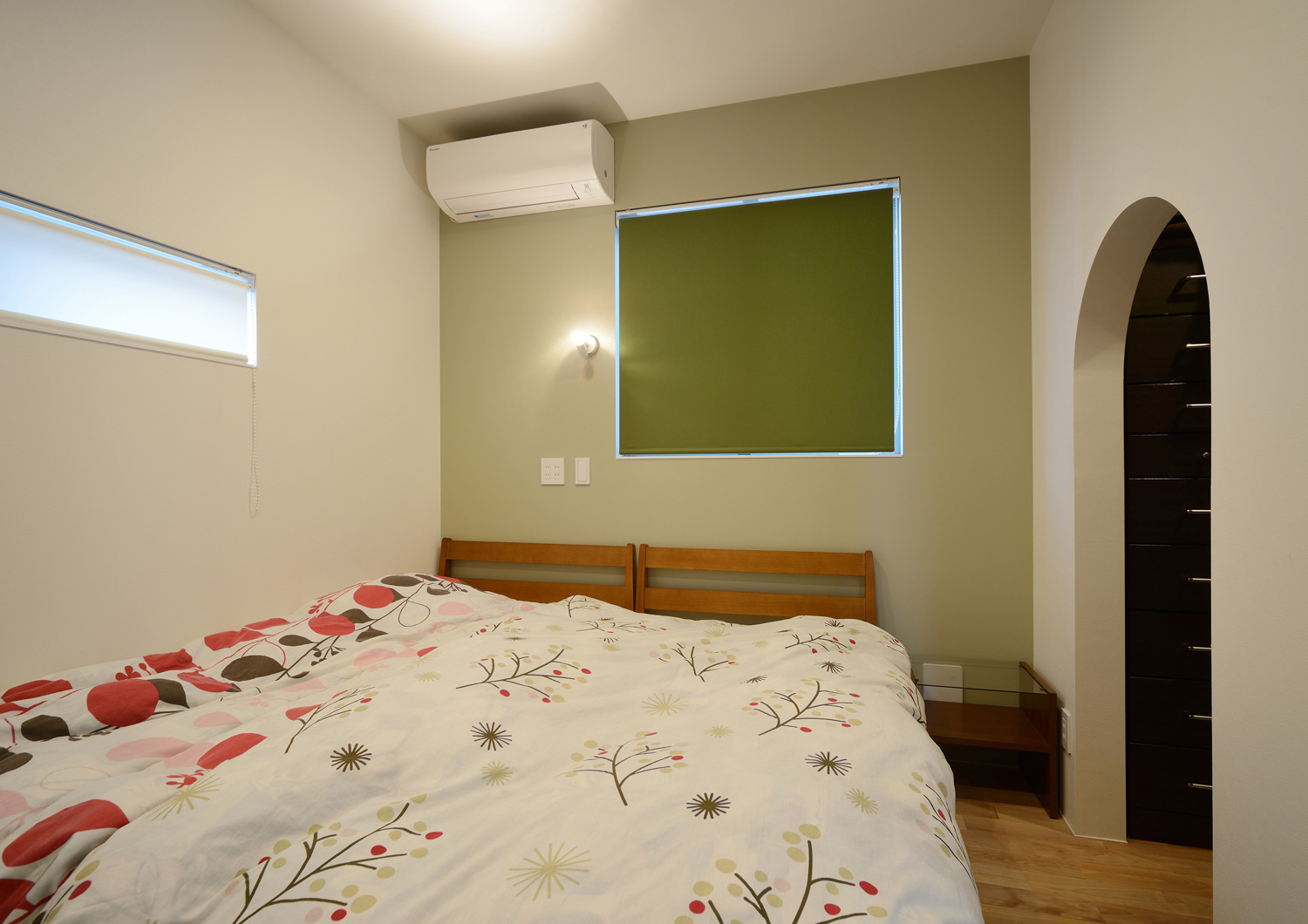 正方形の窓に緑色のカーテンを取り付けた寝室・デザイン住宅