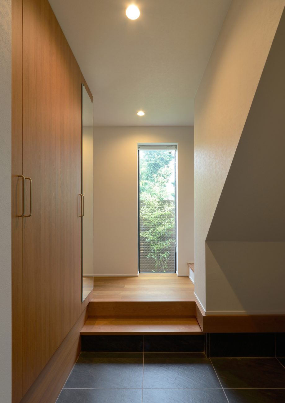 正面に縦長のスリット窓がある明るい玄関・デザイン住宅