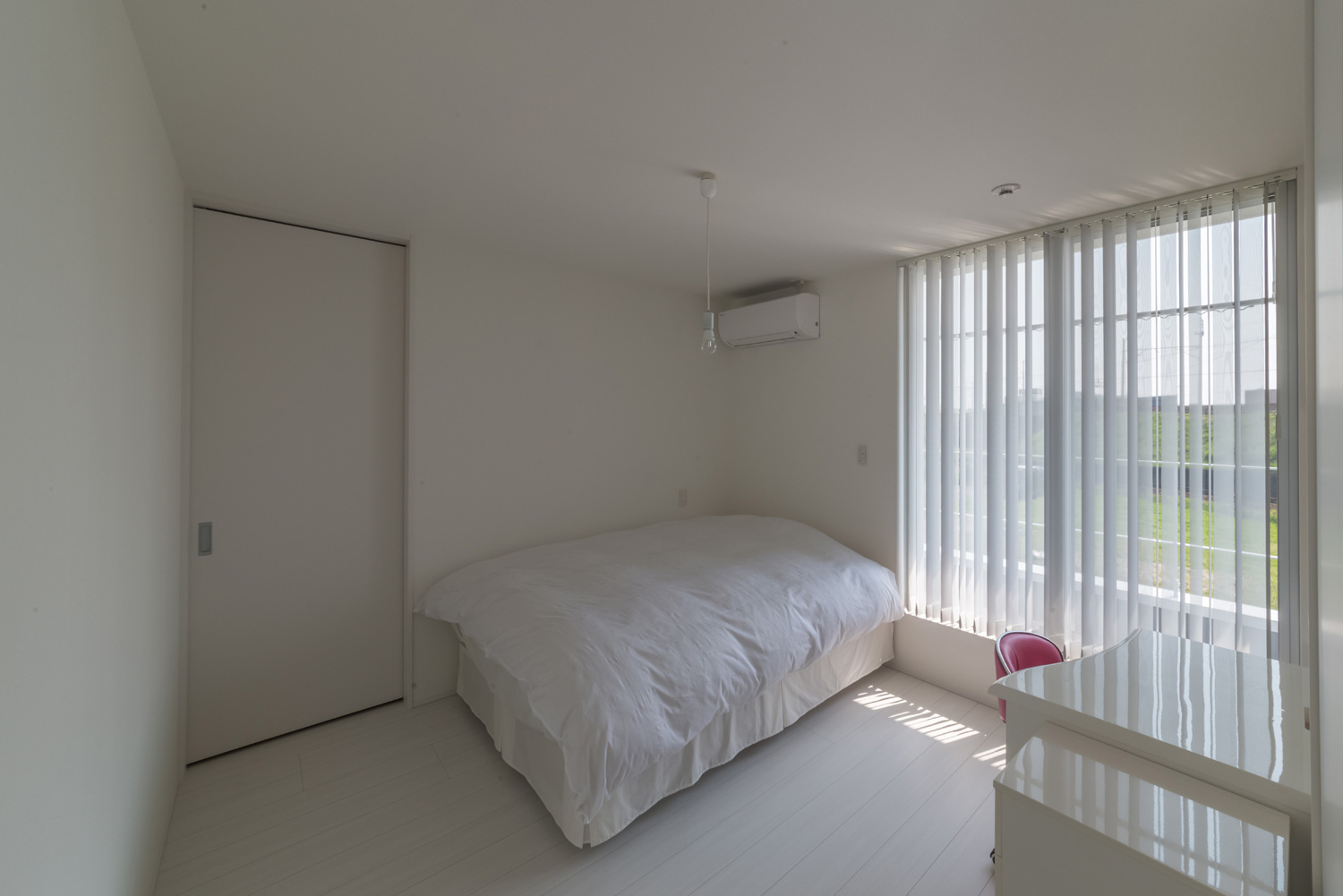 ブラインド付きの窓がある白で統一された寝室・デザイン住宅