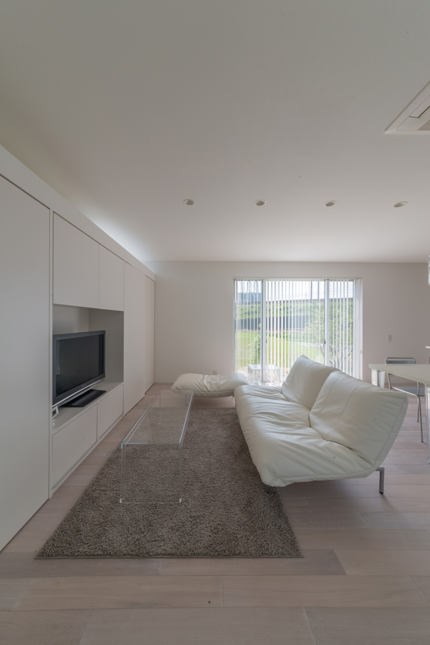 壁面収納の中にテレビが置かれたシンプルでおしゃれなLDK・デザイン住宅