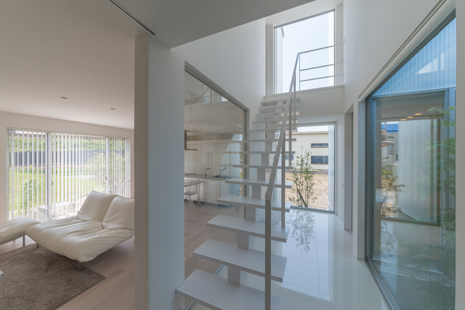 スケルトン階段のある廊下のそばにあるLDK・デザイン住宅