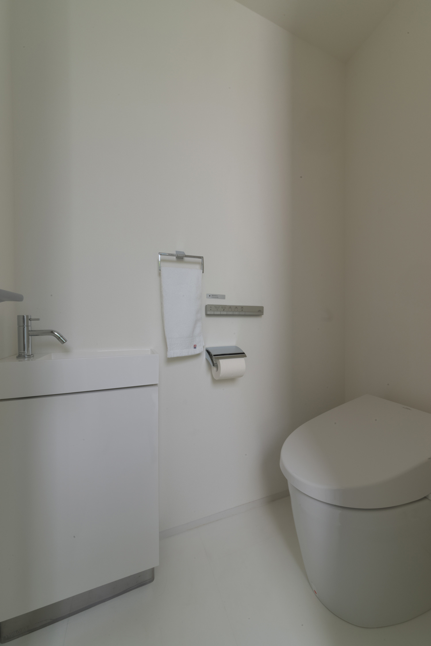 薄型手洗いを取りつけた白いシンプルなトイレ・デザイン住宅