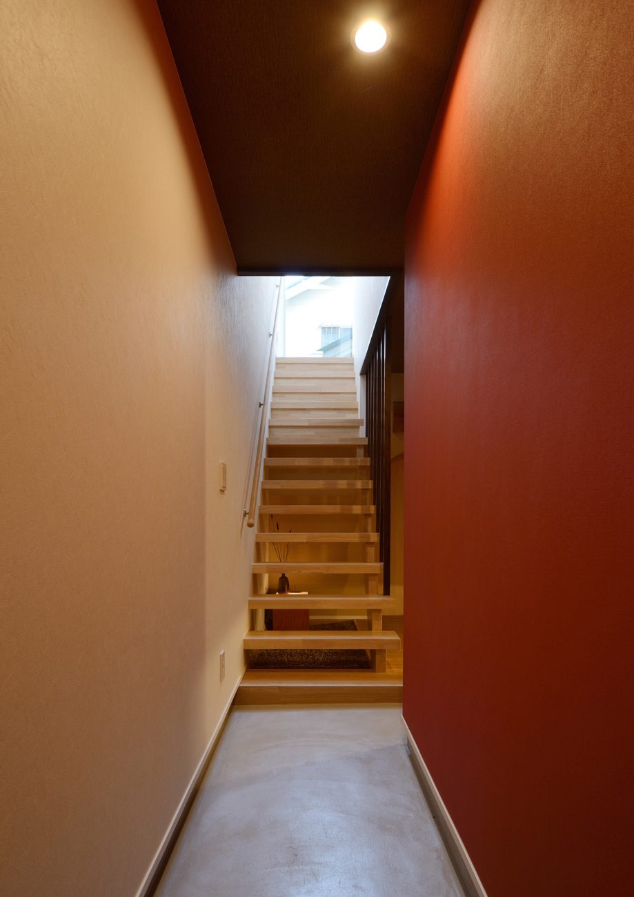 正面に木のスケルトン階段があるモルタルの玄関・デザイン住宅 注文住宅・デザイン住宅建築実例_『CASE444 木洞の家』_玄関