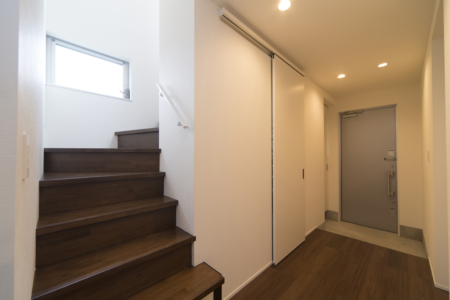 箱型階段がそばにあるモルタルのシンプルな玄関・デザイン住宅 注文住宅・デザイン住宅建築実例_『CASE445 ひとときの家』_玄関