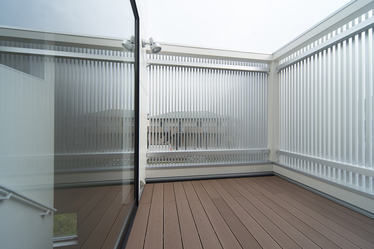 金属のルーバーの目隠しを取り付けたウッドデッキのバルコニー・デザイン住宅 注文住宅・デザイン住宅建築実例_『CASE445 ひとときの家』_テラス・バルコニー