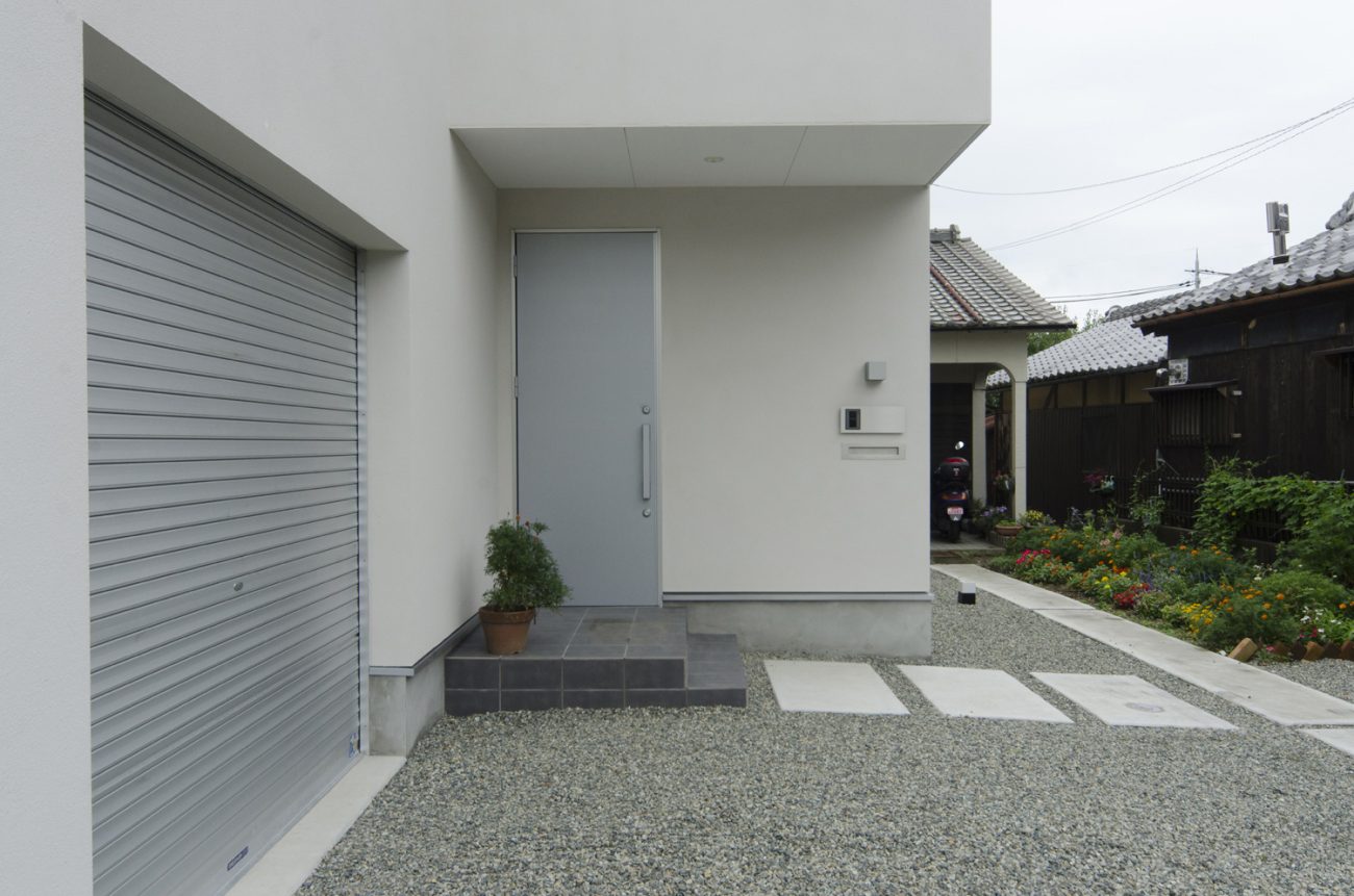 シャッター付きのガレージやシルバーの玄関扉のアプローチがある住まい・デザイン住宅 注文住宅・デザイン住宅建築実例_『CASE448 ひと・つなぐ・いえ』_外観
