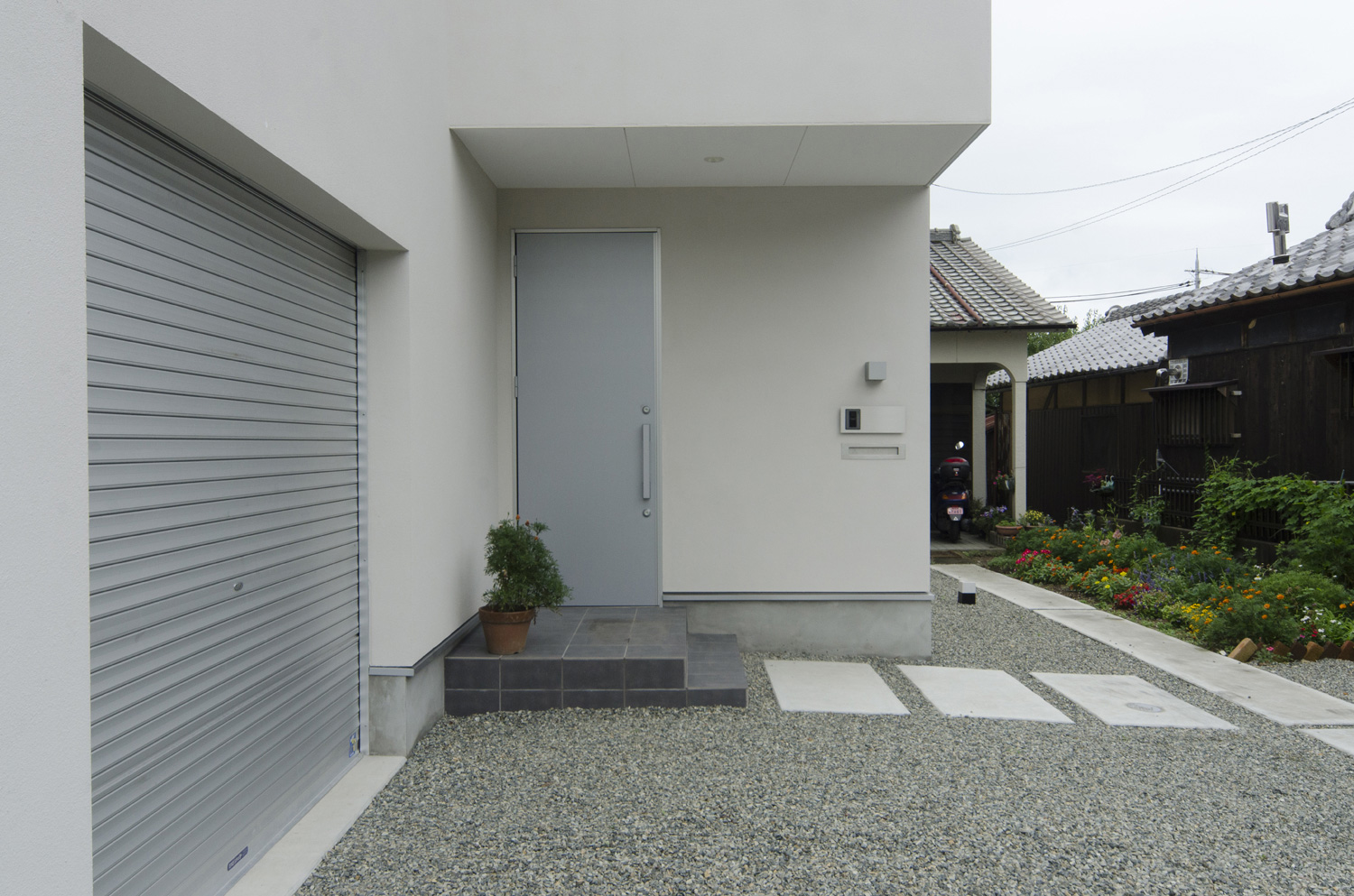 シャッター付きのガレージやシルバーの玄関扉のアプローチがある住まい・デザイン住宅 注文住宅・デザイン住宅建築実例_『CASE448 ひと・つなぐ・いえ』_外観