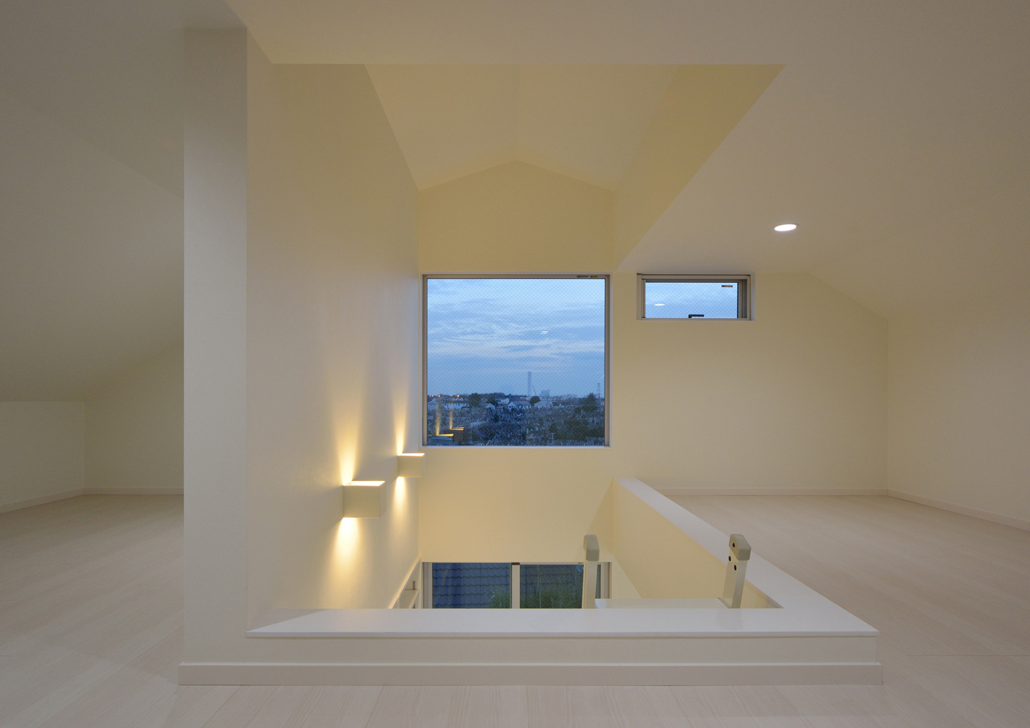 壁に間接照明が取り付けられた外の景色が見られるシンプルなロフト・デザイン住宅 注文住宅・デザイン住宅建築実例_『CASE451 台形の家』_ロフト