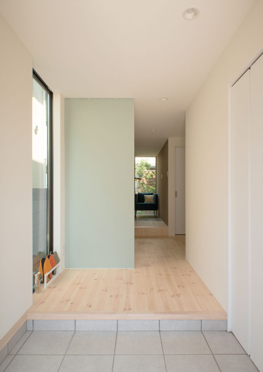 フローリングの廊下と繋がるシンプルなタイルの玄関・デザイン住宅 注文住宅・デザイン住宅建築実例_『CASE453 brun』_玄関