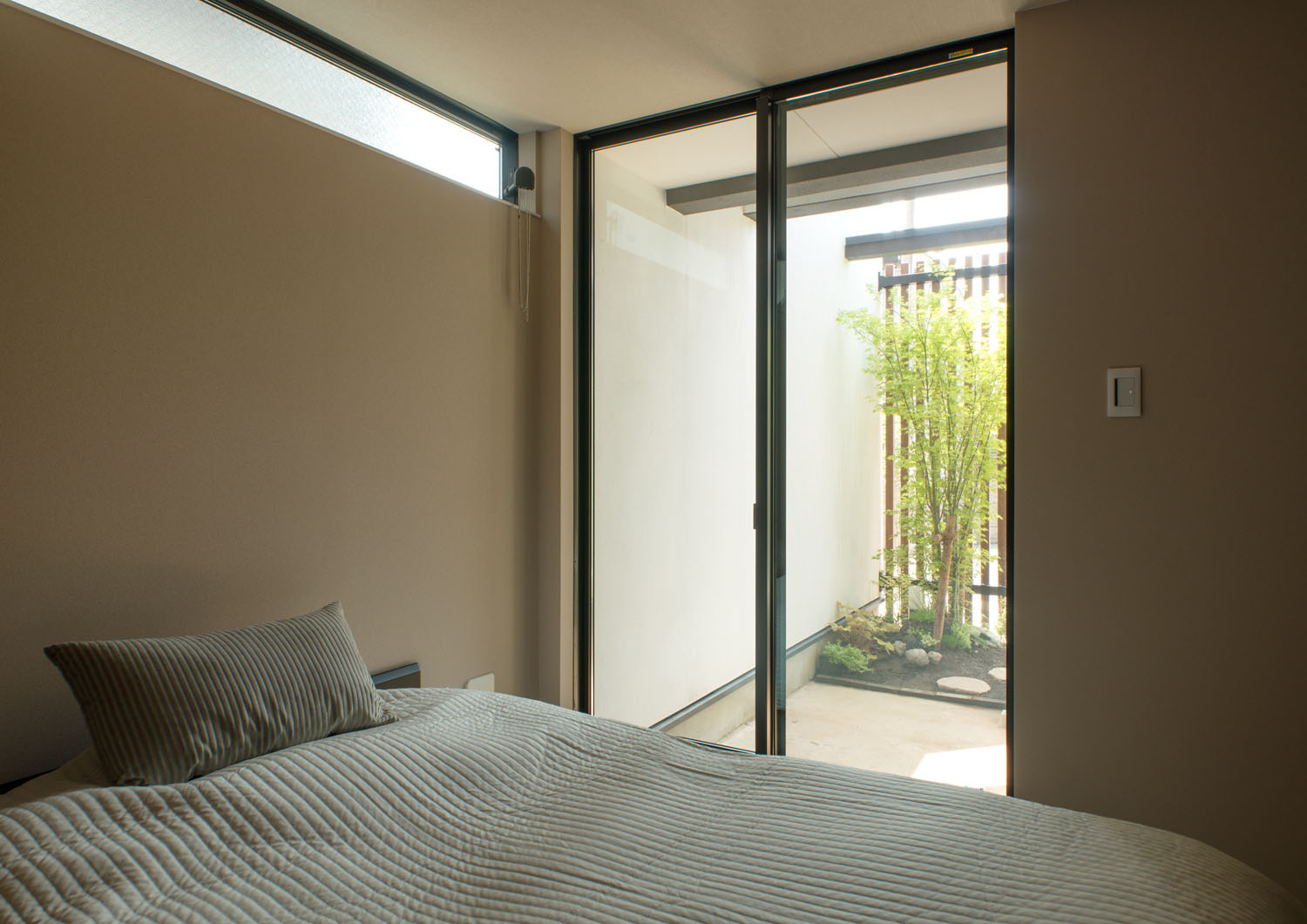 窓から植栽が見えるブラウンの壁の寝室・デザイン住宅 注文住宅・デザイン住宅建築実例_『CASE453 brun』_寝室