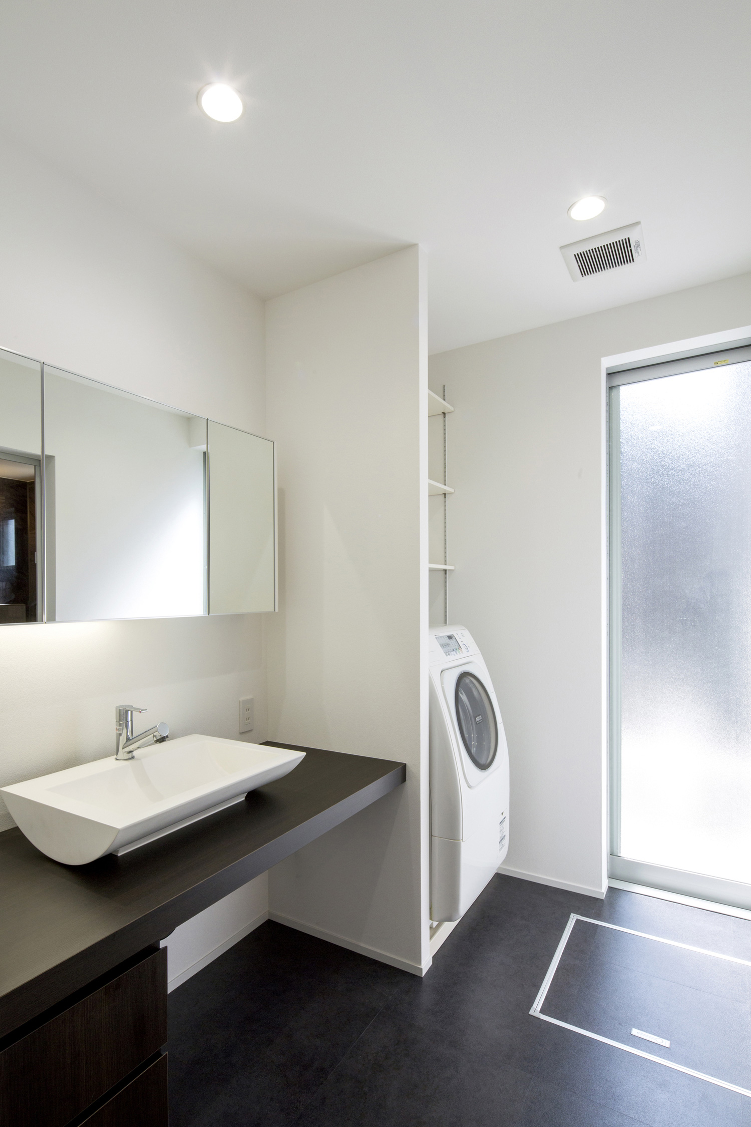 黒い床と黒い洗面台があるスタイリッシュな洗面所・デザイン住宅 注文住宅・デザイン住宅建築実例_『CASE454 bridge』_浴室・洗面所