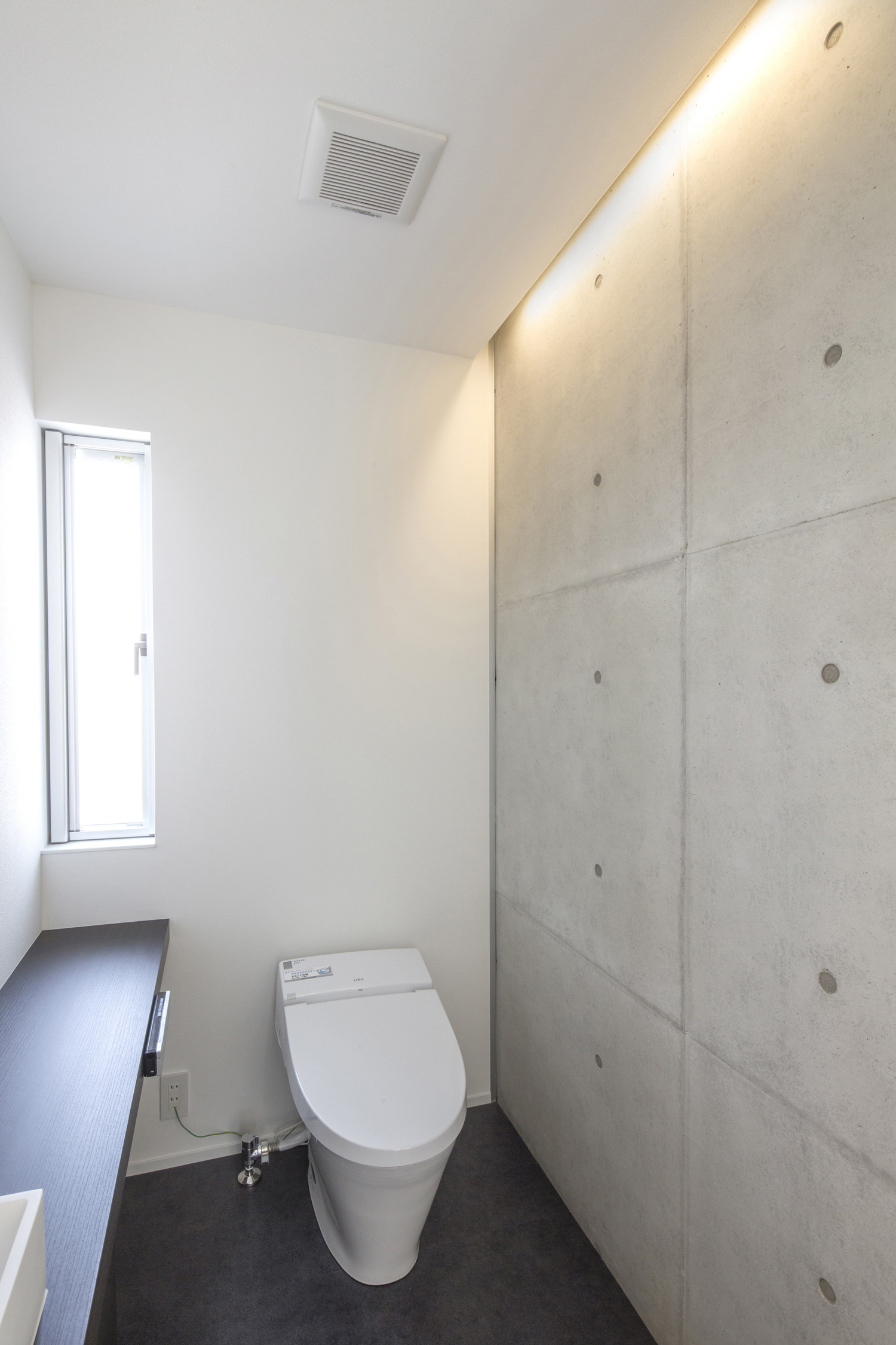コンクリートの壁に間接照明を取り付けたスタイリッシュなトイレ・デザイン住宅 注文住宅・デザイン住宅建築実例_『CASE454 bridge』_トイレ