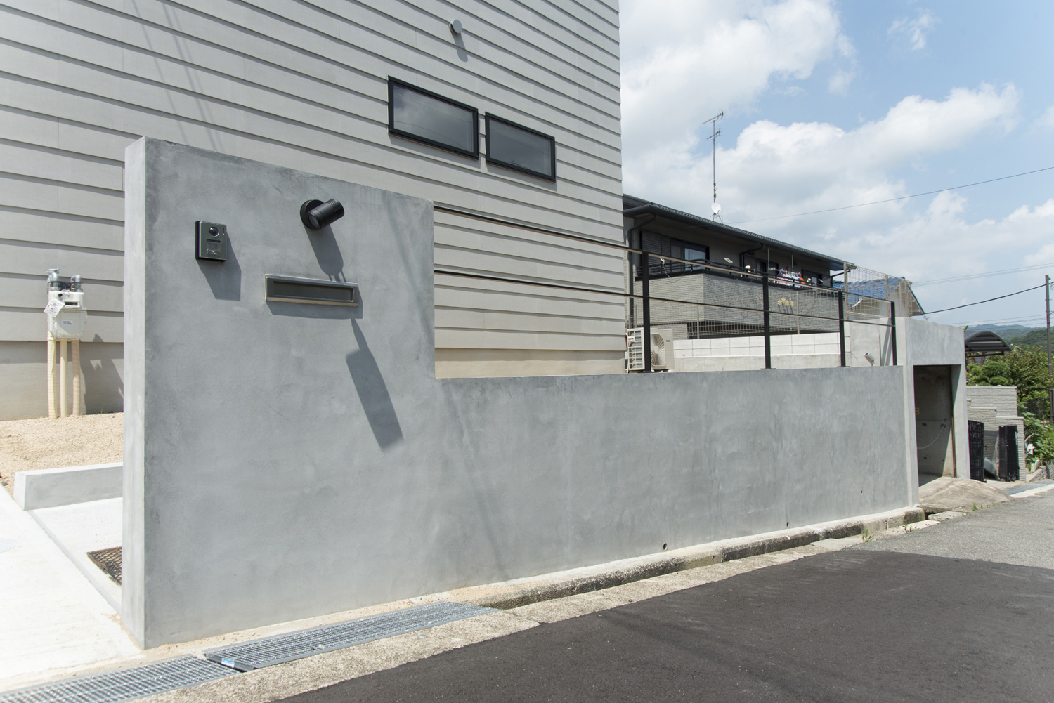 コンクリートの目隠し壁が立てられているグレーの外壁の家の玄関アプローチ・デザイン住宅 注文住宅・デザイン住宅建築実例_『CASE464 無駄のない家』_外観