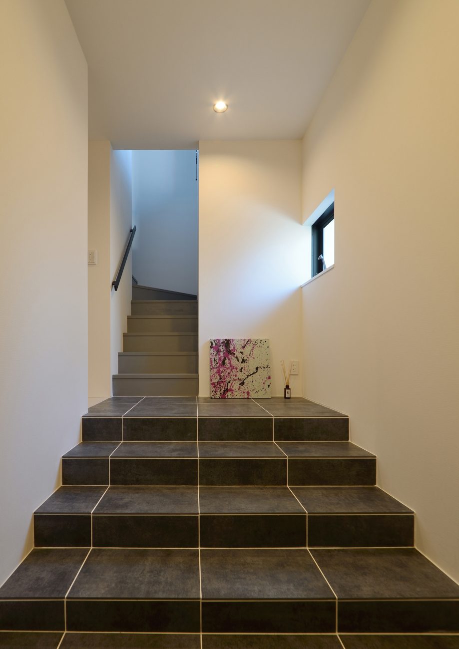 グレーのタイルの階段がある玄関・デザイン住宅 注文住宅・デザイン住宅建築実例_『CASE467 color cube』_玄関