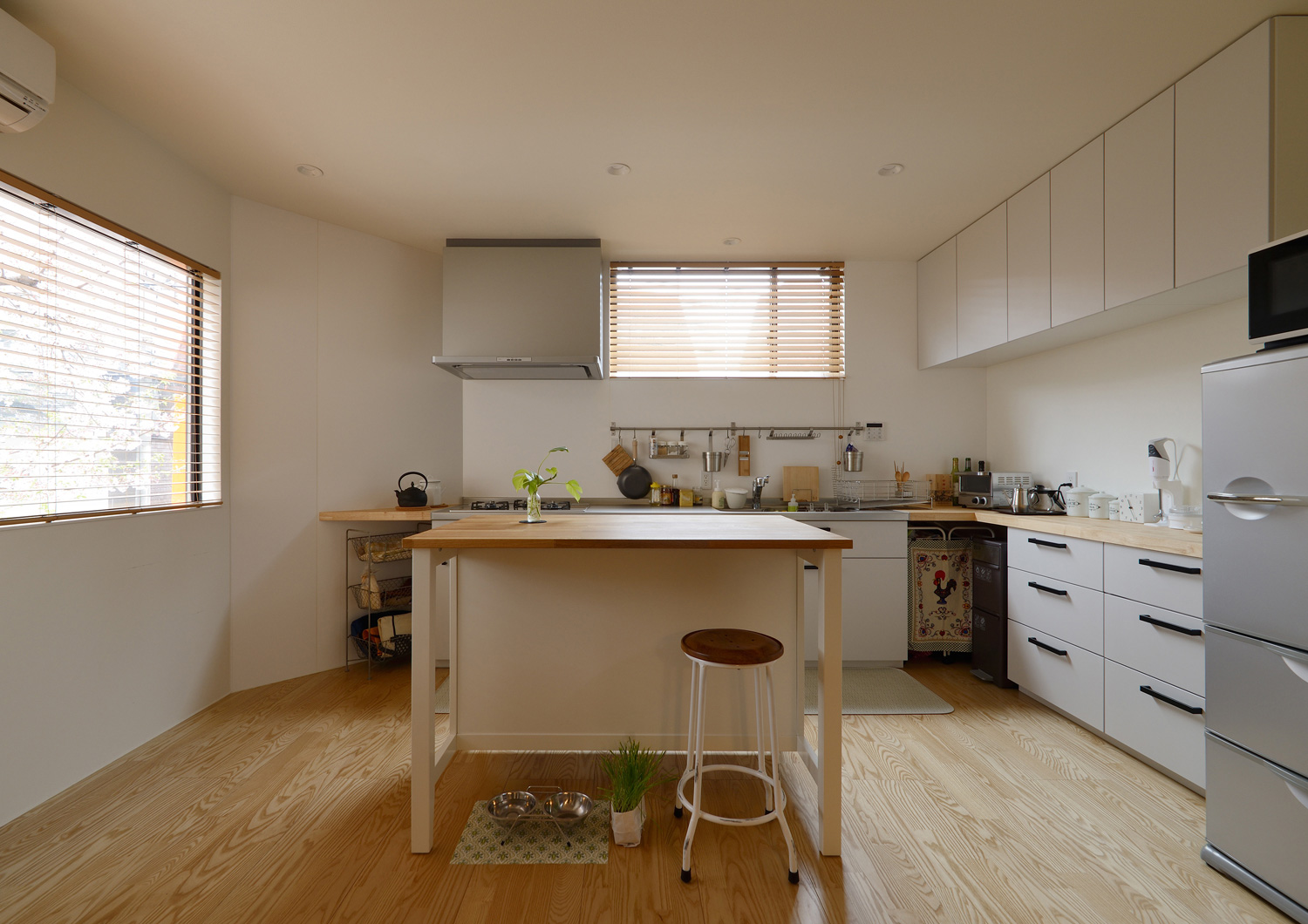 壁付けキッチンの中心にテーブルを置いた広いキッチン・デザイン住宅 注文住宅・デザイン住宅建築実例_『CASE461 眺める家』_キッチン