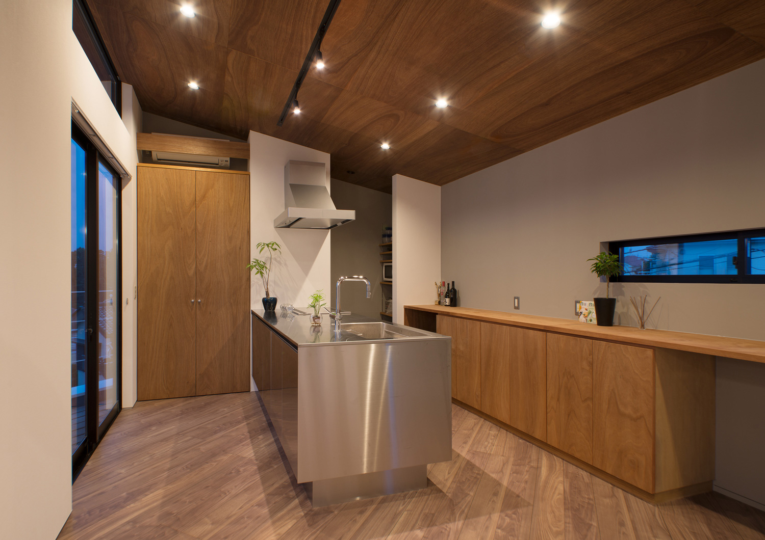 天井にダウンライトを取り付けたステンレスのペニンシュラキッチンがあるLDK・デザイン住宅 注文住宅・デザイン住宅建築実例_『CASE484 やまのいえ』_キッチン