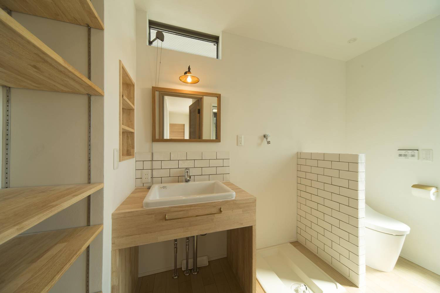 洗面所とトイレがタイルの壁で仕切られたデザイン・デザイン住宅 注文住宅・デザイン住宅建築実例_『CASE490 自然の家』_浴室・洗面所