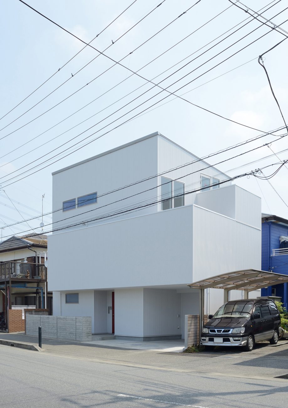 白いシンプルな外壁の住まいを斜めから見た様子・デザイン住宅 注文住宅・デザイン住宅建築実例_『CASE498 シロイイエ』_外観