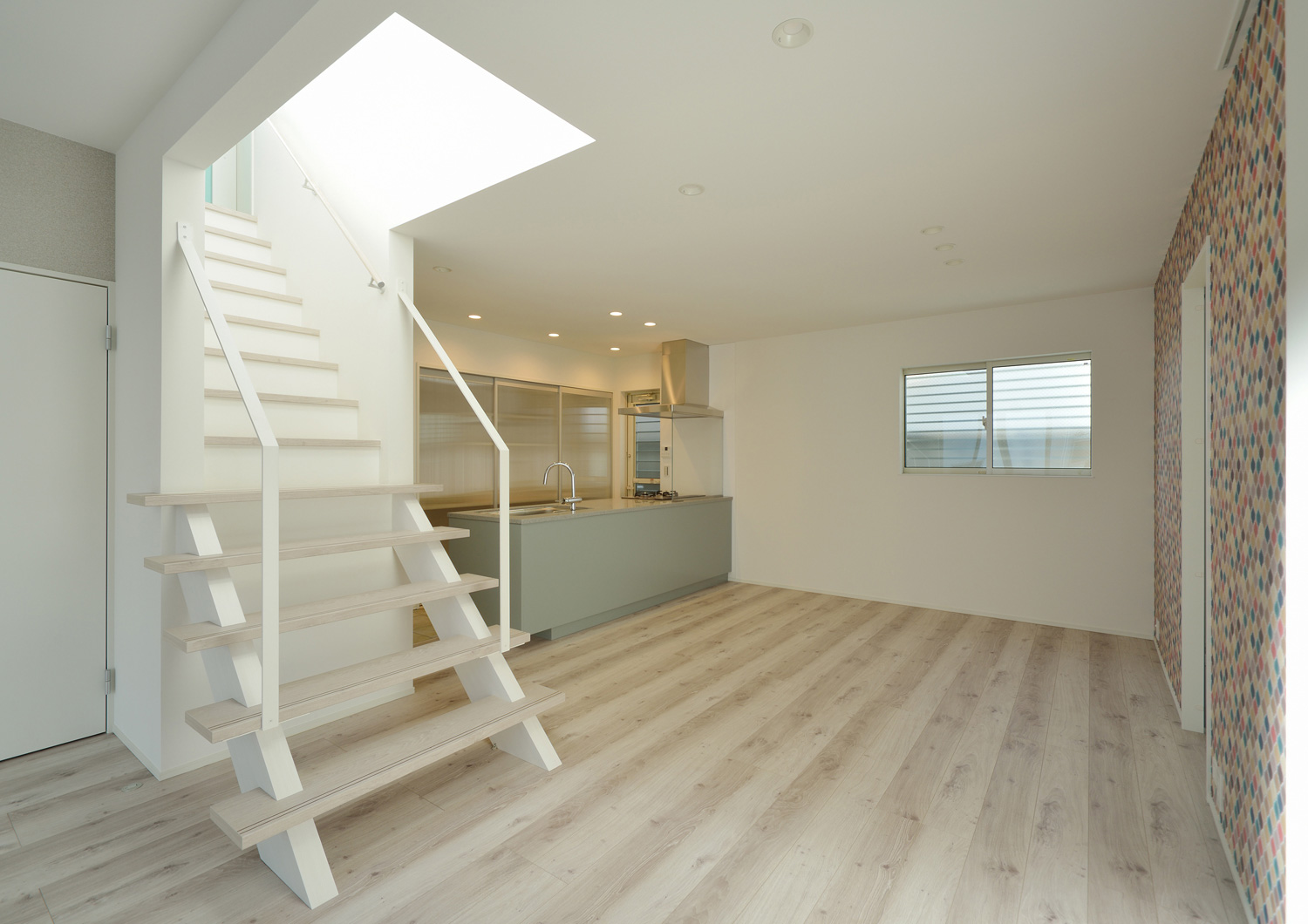 カラフルなタイルのアクセントウォールを設けた白いリビングイン階段のあるシンプルなLDK・デザイン住宅 注文住宅・デザイン住宅建築実例_『CASE503 ヒカリノソソグイエ』_LDK