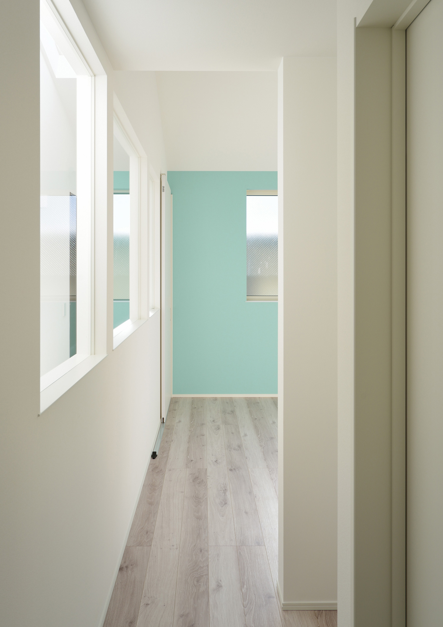 廊下から水色のアクセントクロスがある部屋をみた様子・デザイン住宅 注文住宅・デザイン住宅建築実例_『CASE503 ヒカリノソソグイエ』_廊下