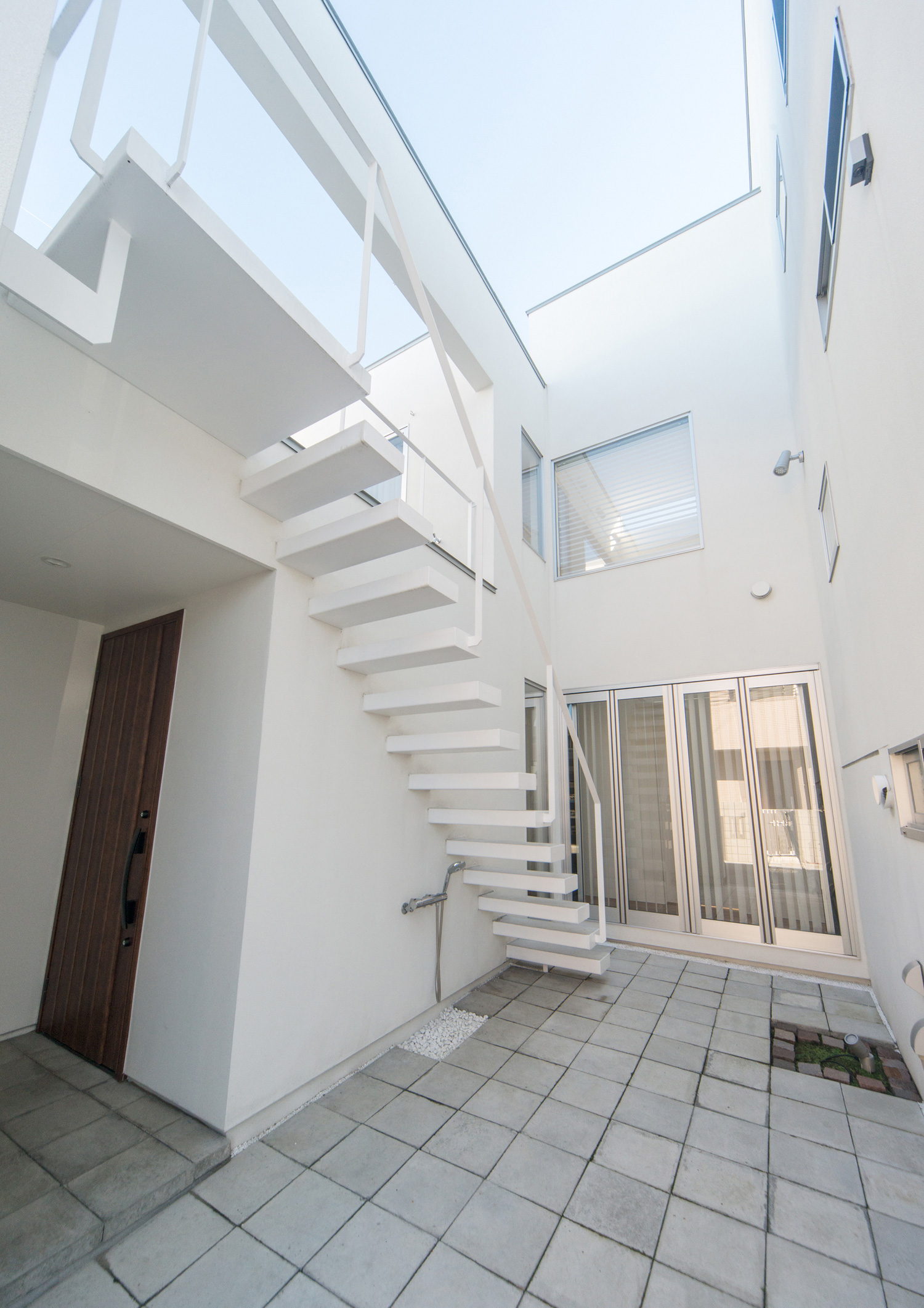 壁に囲まれた白い外階段のある中庭・デザイン住宅 注文住宅・デザイン住宅建築実例_『CASE504 中庭と３つのテラスのある家』_中庭