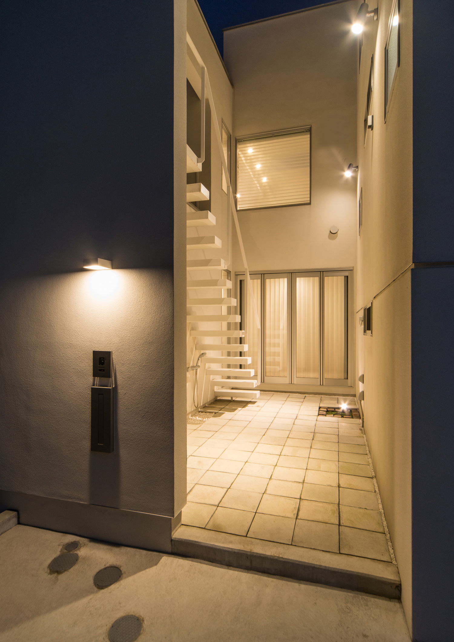 壁に間接照明が取り付けられたプライベートな中庭・デザイン住宅 注文住宅・デザイン住宅建築実例_『CASE504 中庭と３つのテラスのある家』_中庭