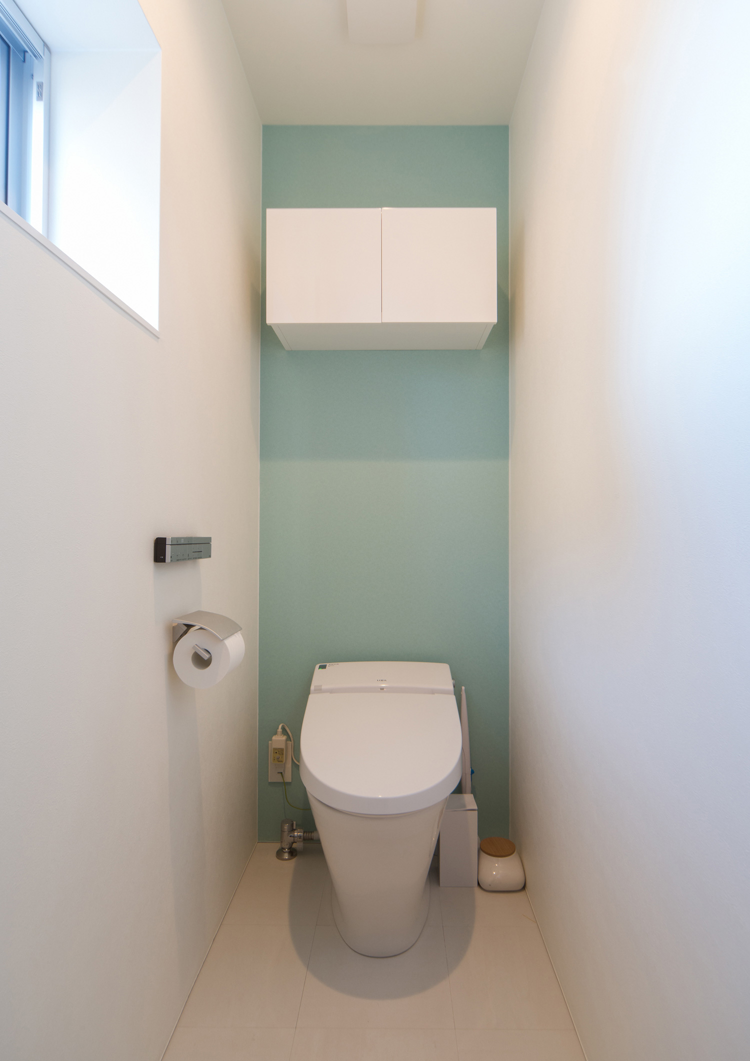 ミントグリーンのアクセントクロスに収納ボックスを取り付けたシンプルなトイレ・デザイン住宅 注文住宅・デザイン住宅建築実例_『CASE504 中庭と３つのテラスのある家』_トイレ