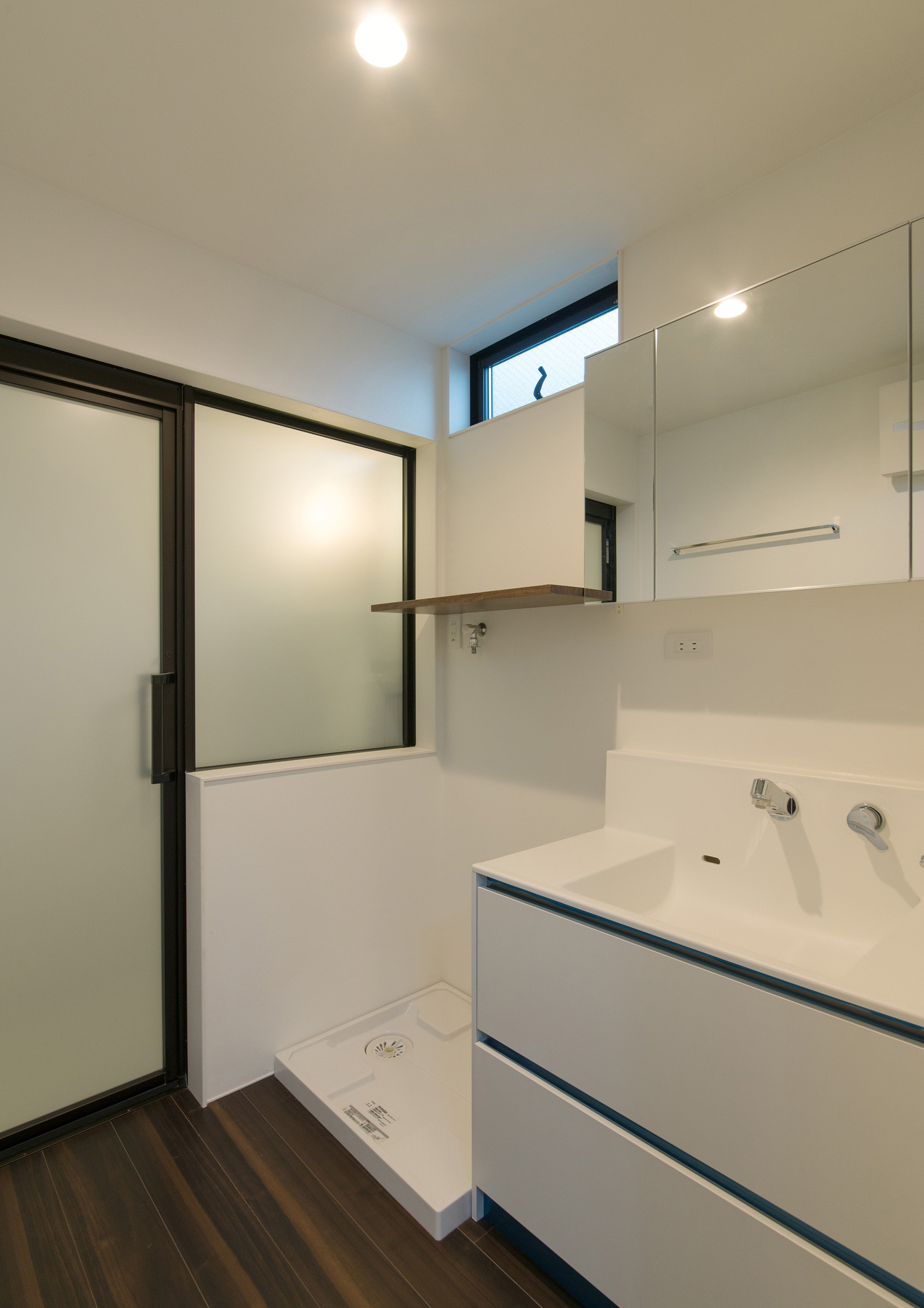 白で統一されたダークブラウンのフローリングのおしゃれな洗面所・デザイン住宅 注文住宅・デザイン住宅建築実例_『CASE507 重なる家』_浴室・洗面所