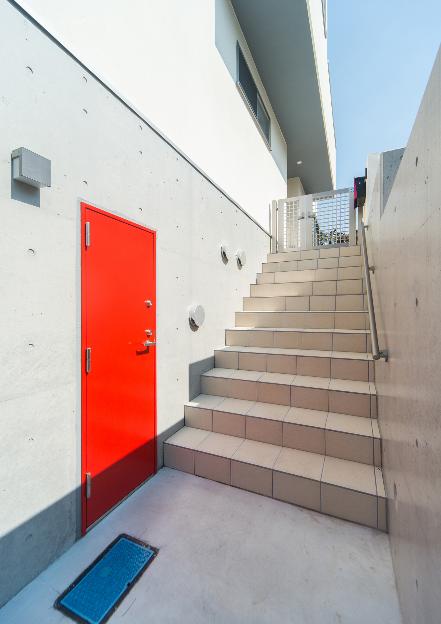 コンクリート打ち放しの壁に赤い扉を取り付けた家・デザイン住宅 注文住宅・デザイン住宅建築実例_『CASE511 高台のガレージハウス』_外観