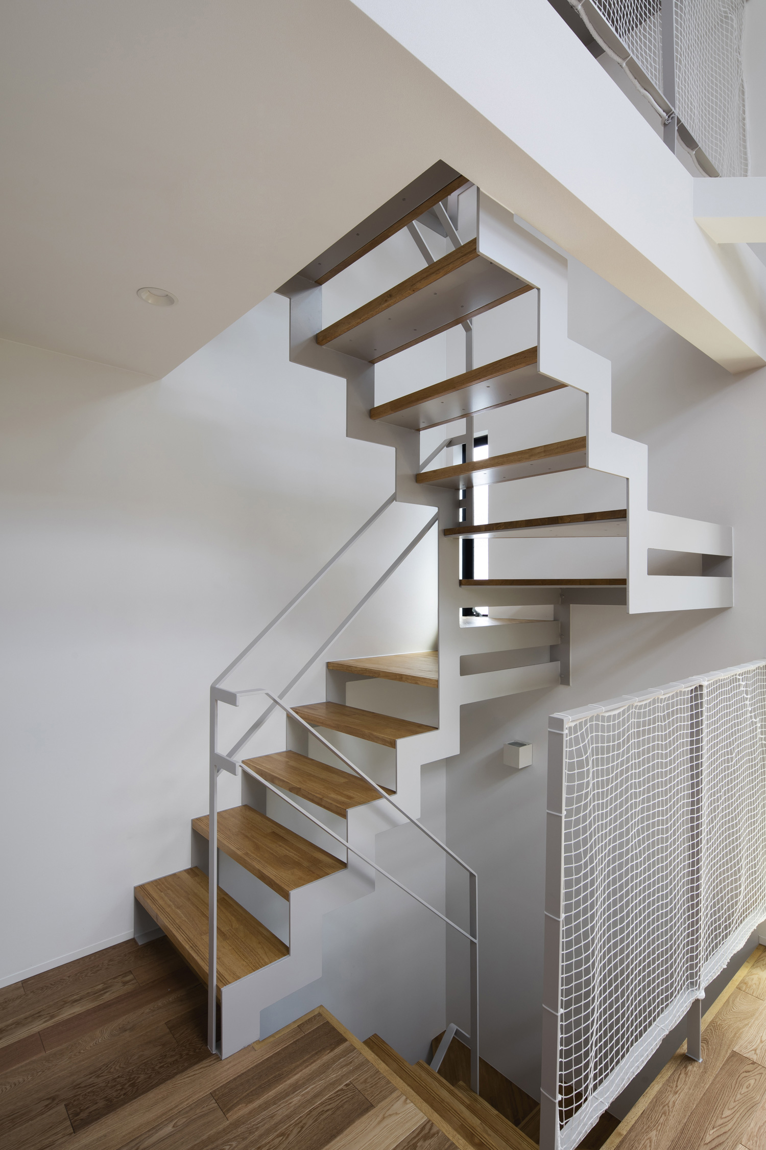 柵にネットを取り付けた木のスケルトン階段の階段室・デザイン住宅 注文住宅・デザイン住宅建築実例_『CASE512 a　c　r　o　s　s』_階段