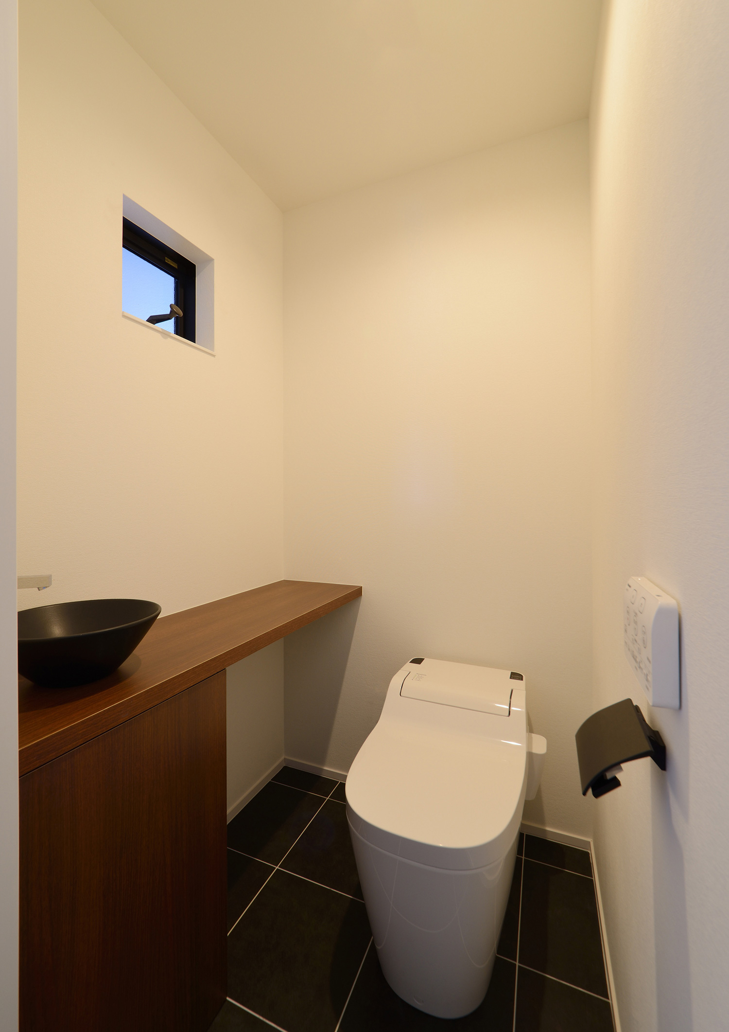 木の手洗いカウンターに黒い洗面ボウルがあるトイレ・デザイン住宅 注文住宅・デザイン住宅建築実例_『CASE514 Slanting Hat』_トイレ