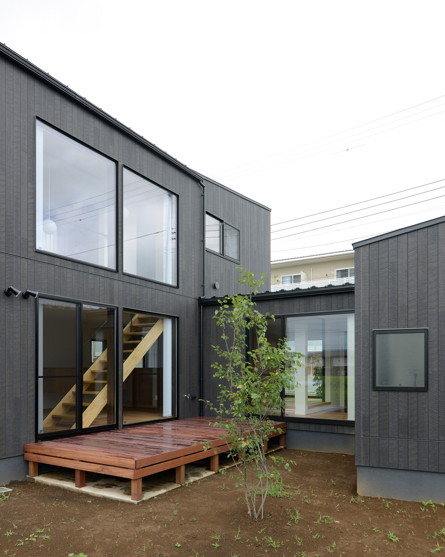 中庭にウッドデッキや植栽がある黒い外壁のおしゃれな外観・デザイン住宅 注文住宅・デザイン住宅建築実例_『CASE520 素地の家』_外観