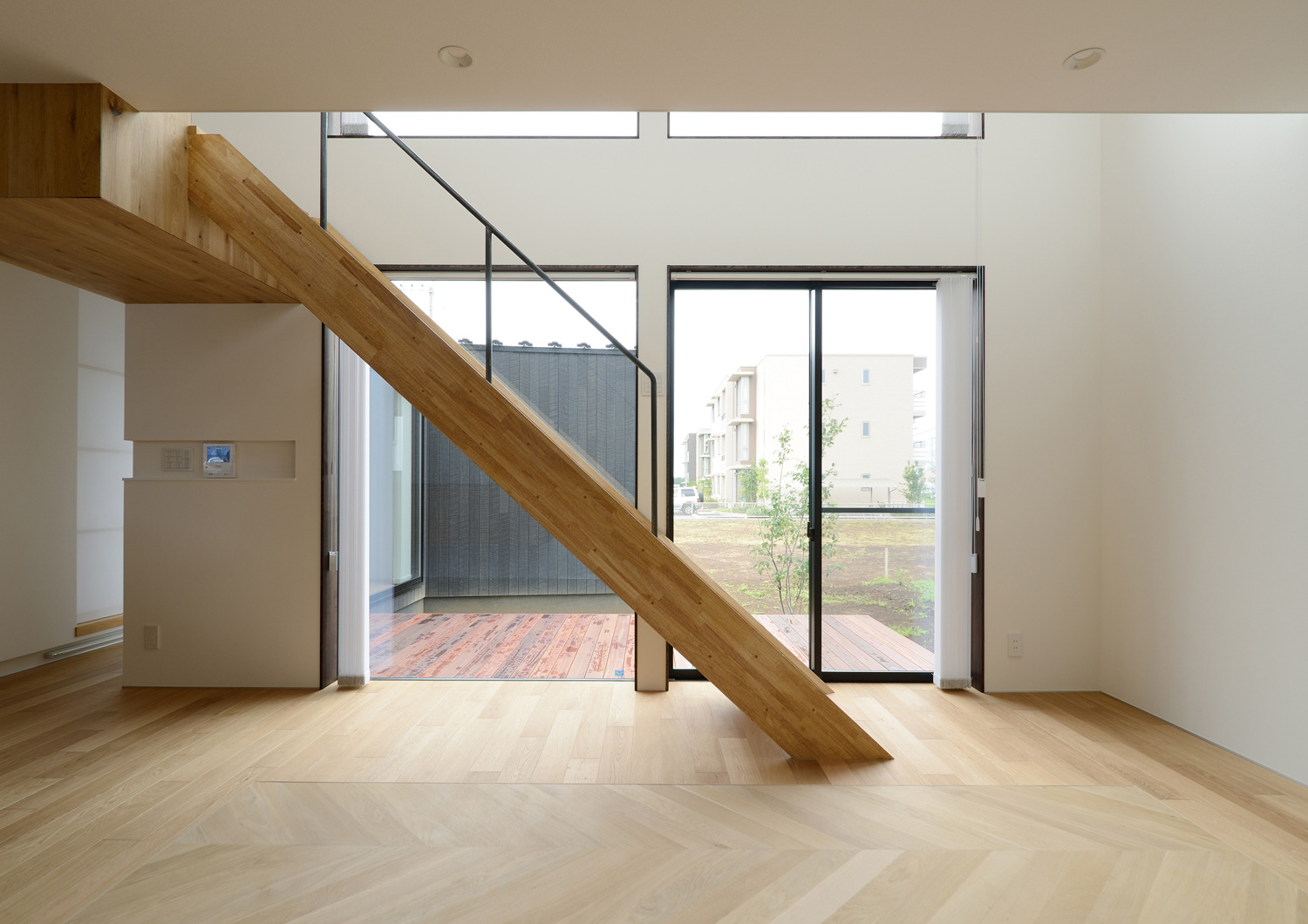 中庭のウッドデッキとフラットに繋がる、リビングイン階段のあるLDK・デザイン住宅 注文住宅・デザイン住宅建築実例_『CASE520 素地の家』_LDK