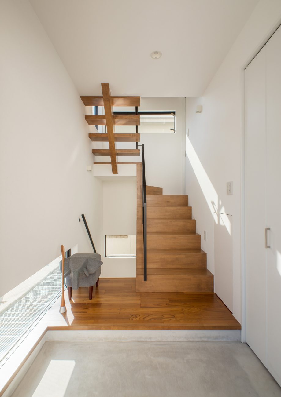 正面に階段がある地窓付きのモルタル玄関・デザイン住宅 注文住宅・デザイン住宅建築実例_『CASE521 緑地公園に隣接する三角屋根の家』_玄関