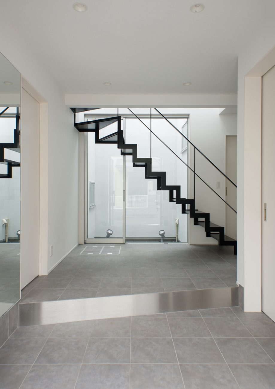 正面にスケルトン階段と窓があるグレーのタイルの玄関・デザイン住宅 注文住宅・デザイン住宅建築実例_『CASE522 LAYER – HOUSE』_玄関
