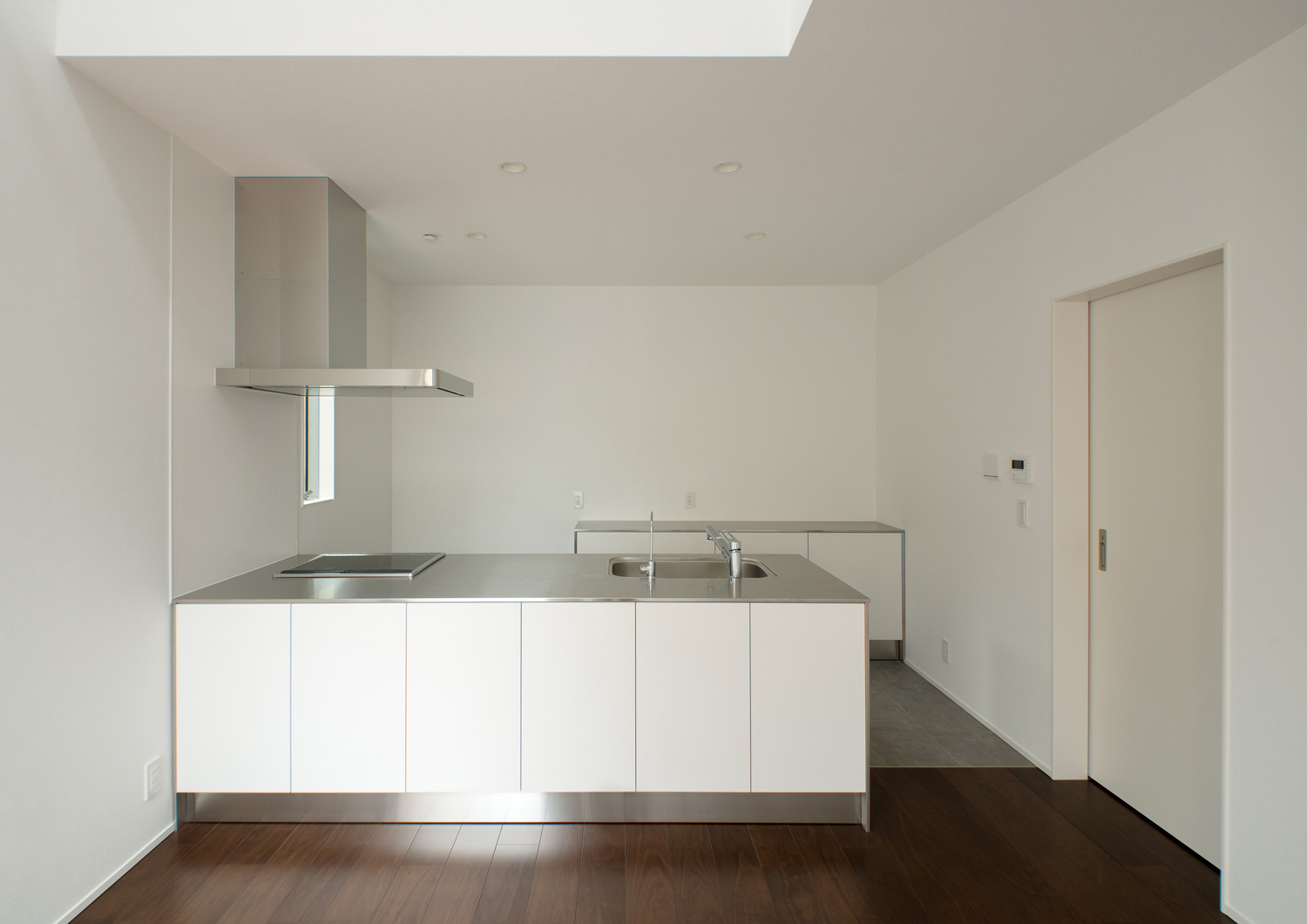 白とステンレスのシンプルなキッチンがあるLDK・デザイン住宅 注文住宅・デザイン住宅建築実例_『CASE522 LAYER – HOUSE』_キッチン