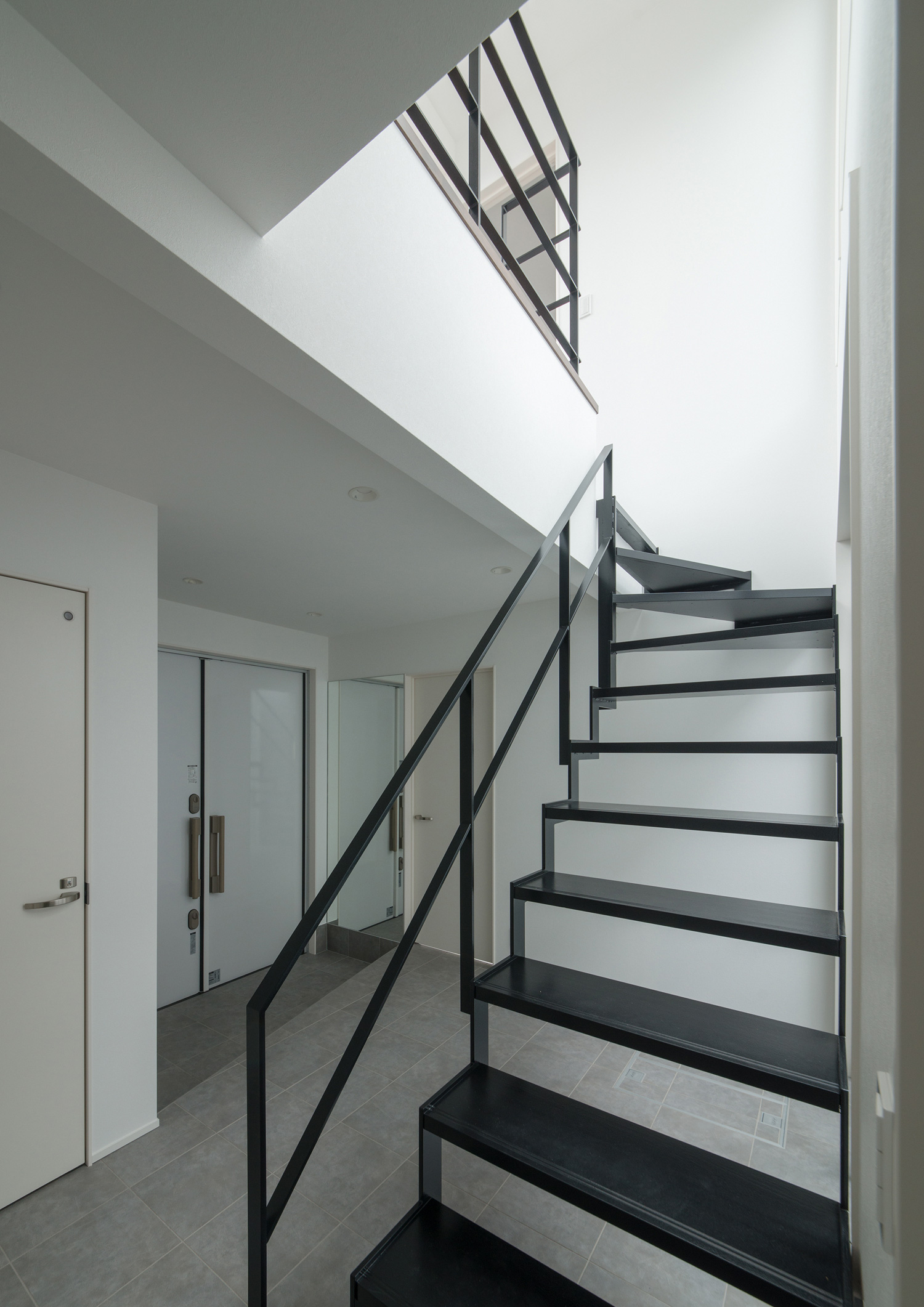 シャープなアイアンのスケルトン階段がある、モノトーンの廊下・デザイン住宅 注文住宅・デザイン住宅建築実例_『CASE522 LAYER – HOUSE』_階段